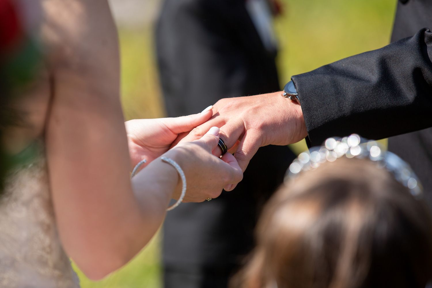 Close-up of groom placing wedding ring on brides finger during outdoor ceremony in Kananaskis, Alberta.