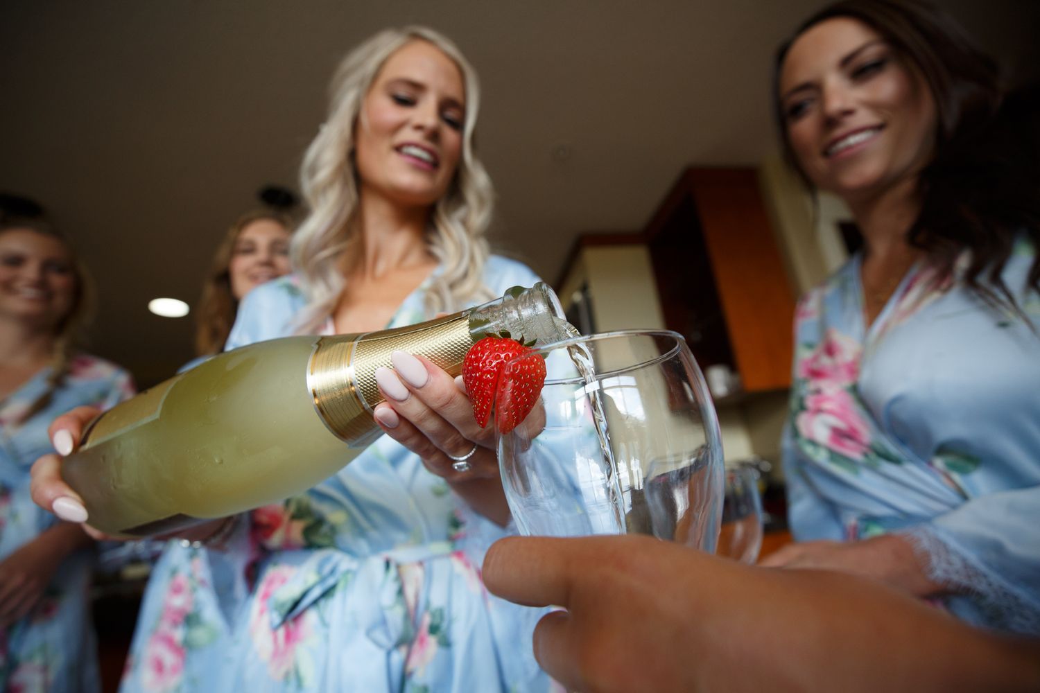 A person pours champagne into a glass during a celebration event.