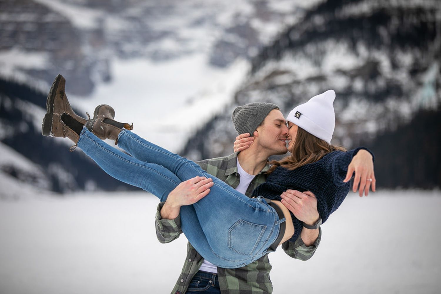 A romantic couple dips while dancing together in a snowy winter landscape at Lake Louise in the Canadian Rockies.