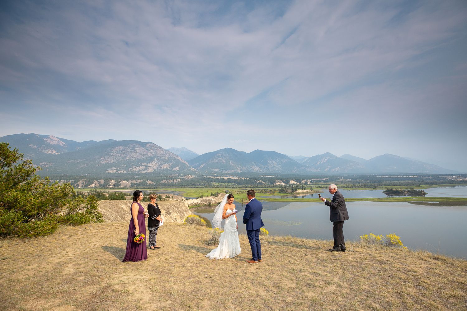 Panoramic mountain landscape view with wedding ceremony group gathered on scenic overlook during outdoor celebration.
Wetland Invermere, BC.