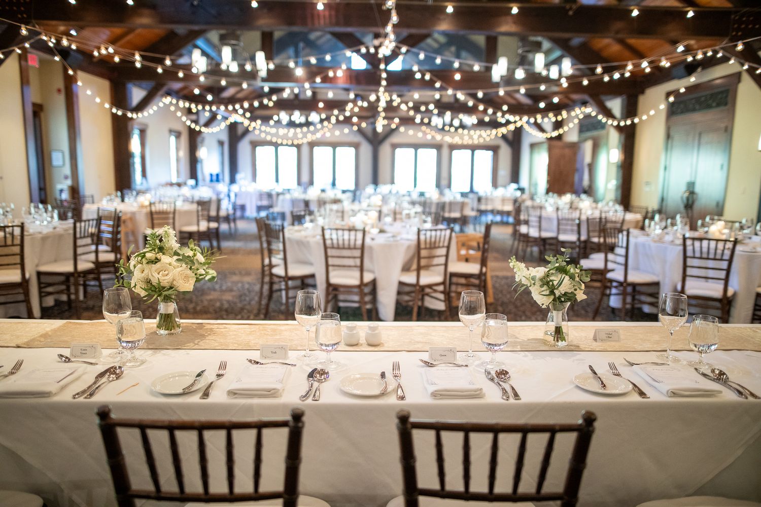 Elegant wedding reception venue with string lights, round tables, and white linens set for a formal dining experience at Silvertip resort.