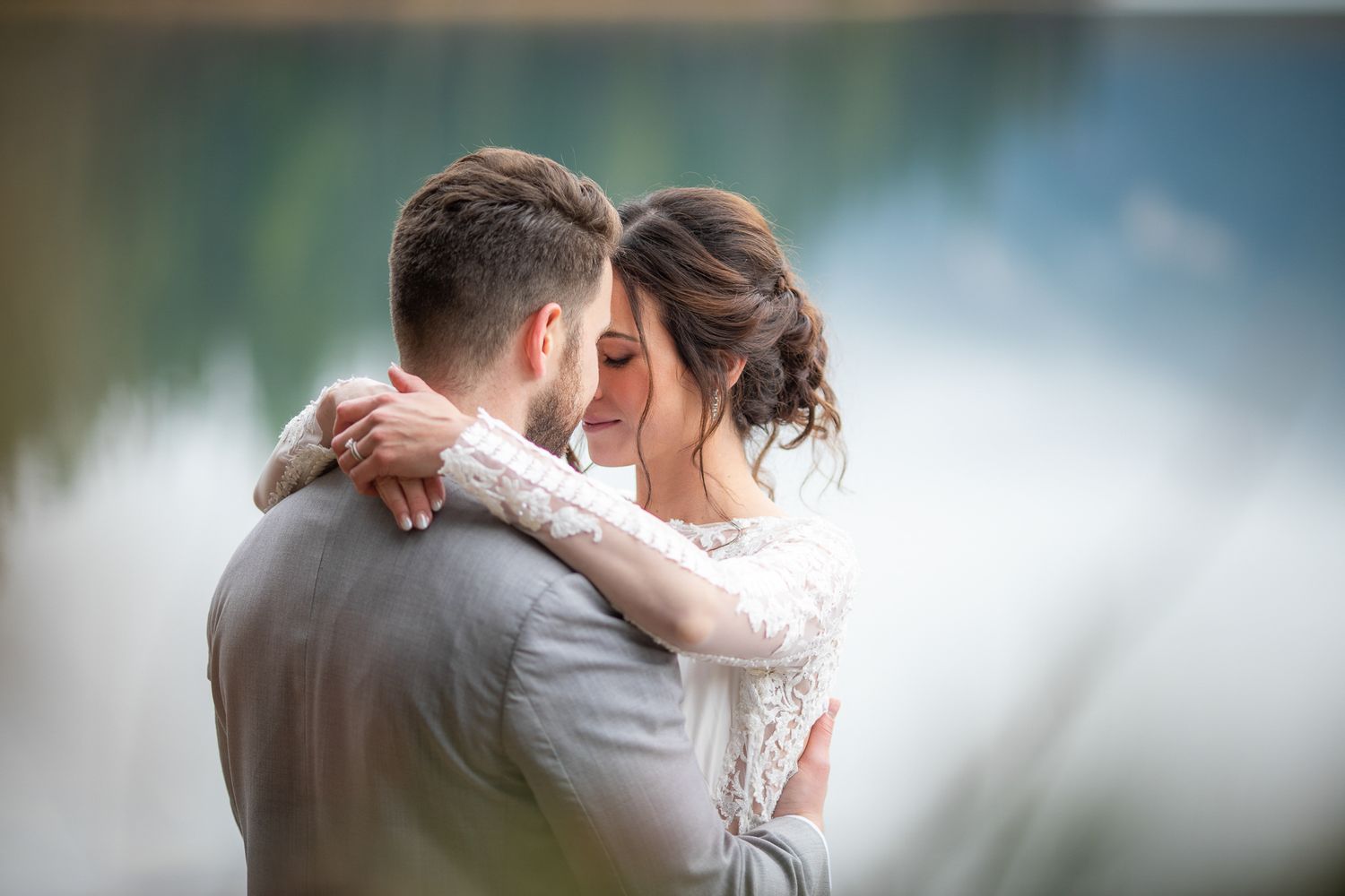 Tender wedding moments captured by lake with soft focus and natural lighting at Emerald Lake Lodge, BC