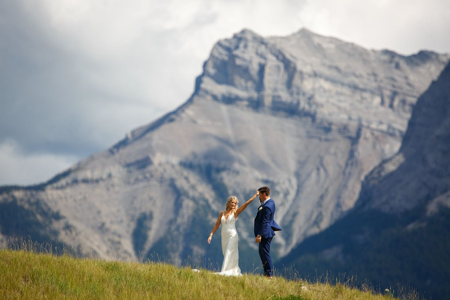 A couple celebrates their wedding day against the dramatic backdrop of rocky mountain peaks in Banff National Park.