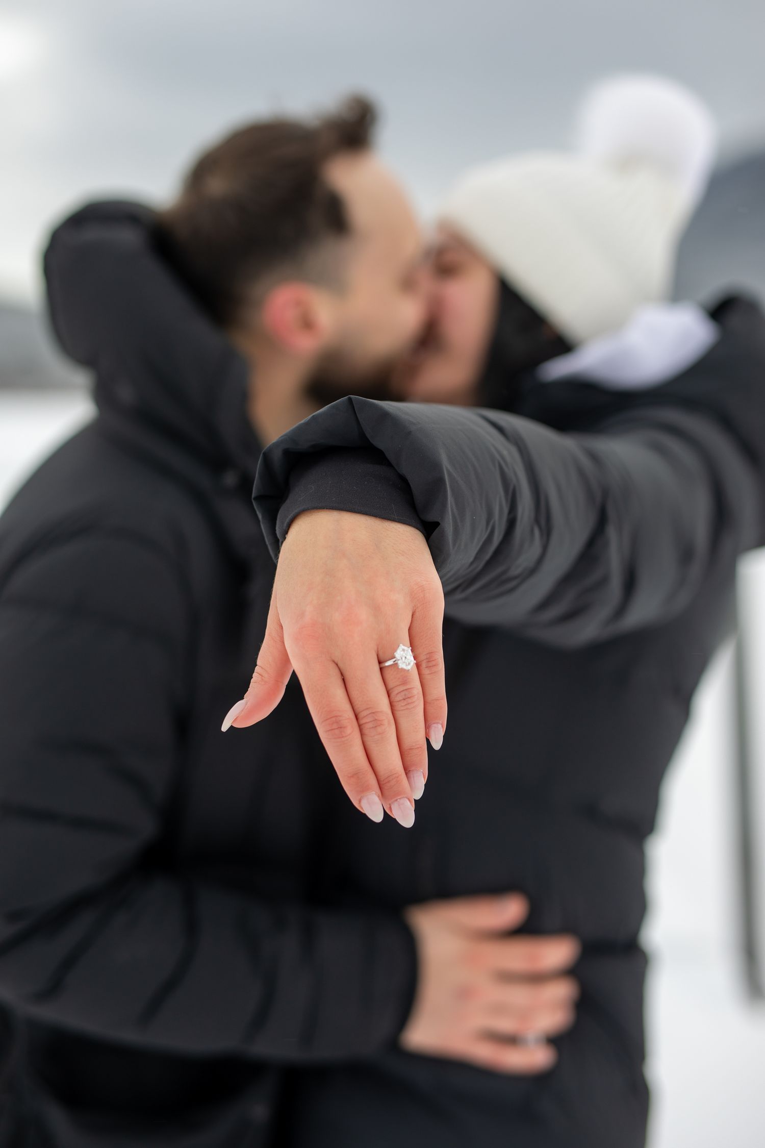 A person in a black coat shows off their engagement ring in a series of progressive close-up shots.  Vermilion lakes in Banff. AB