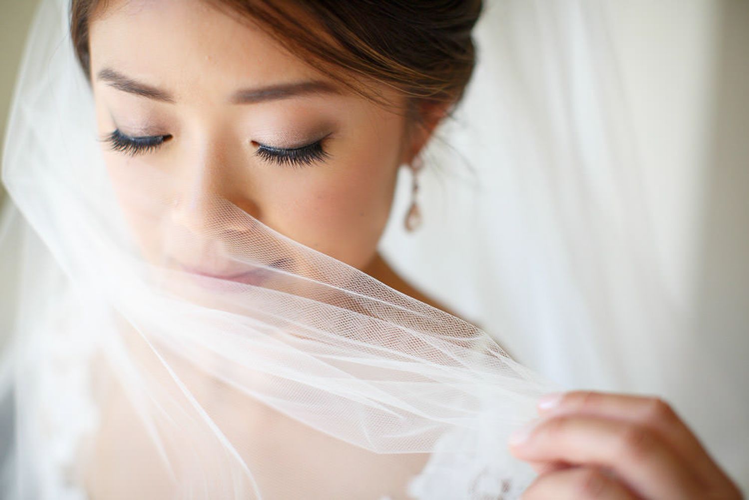 Close-up of bride wearing delicate white veil with soft natural makeup and closed eyes. Fairmont Banff springs hotel. Banff