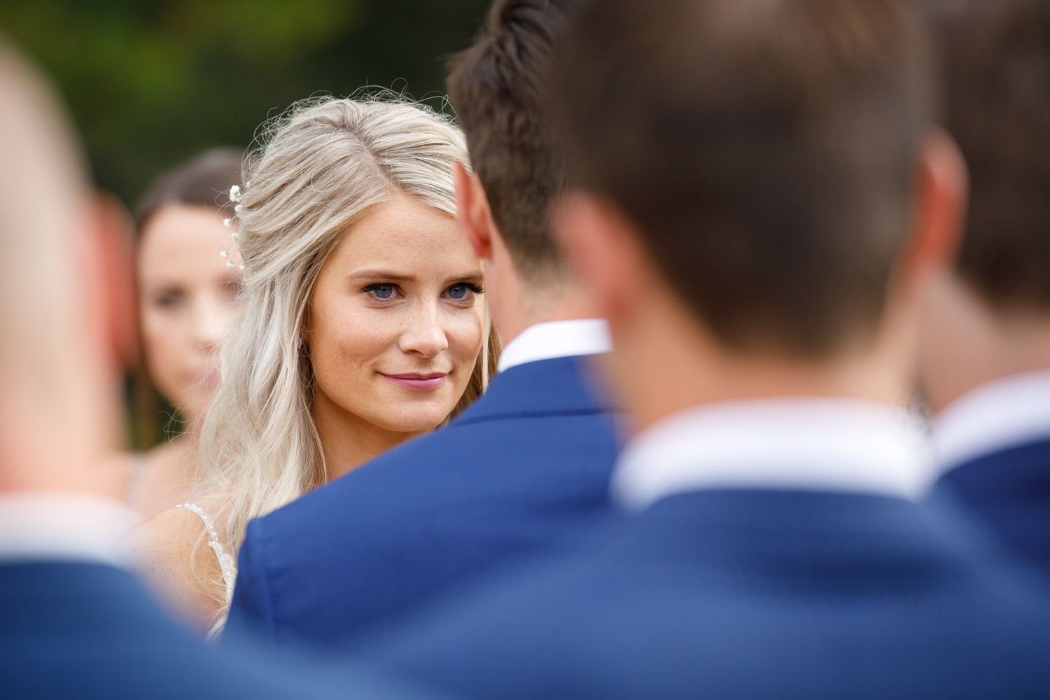A series of wedding photos showing a bride and groomsmen in navy blue suits outdoors at Silvertip resort gazebo in Canmore.