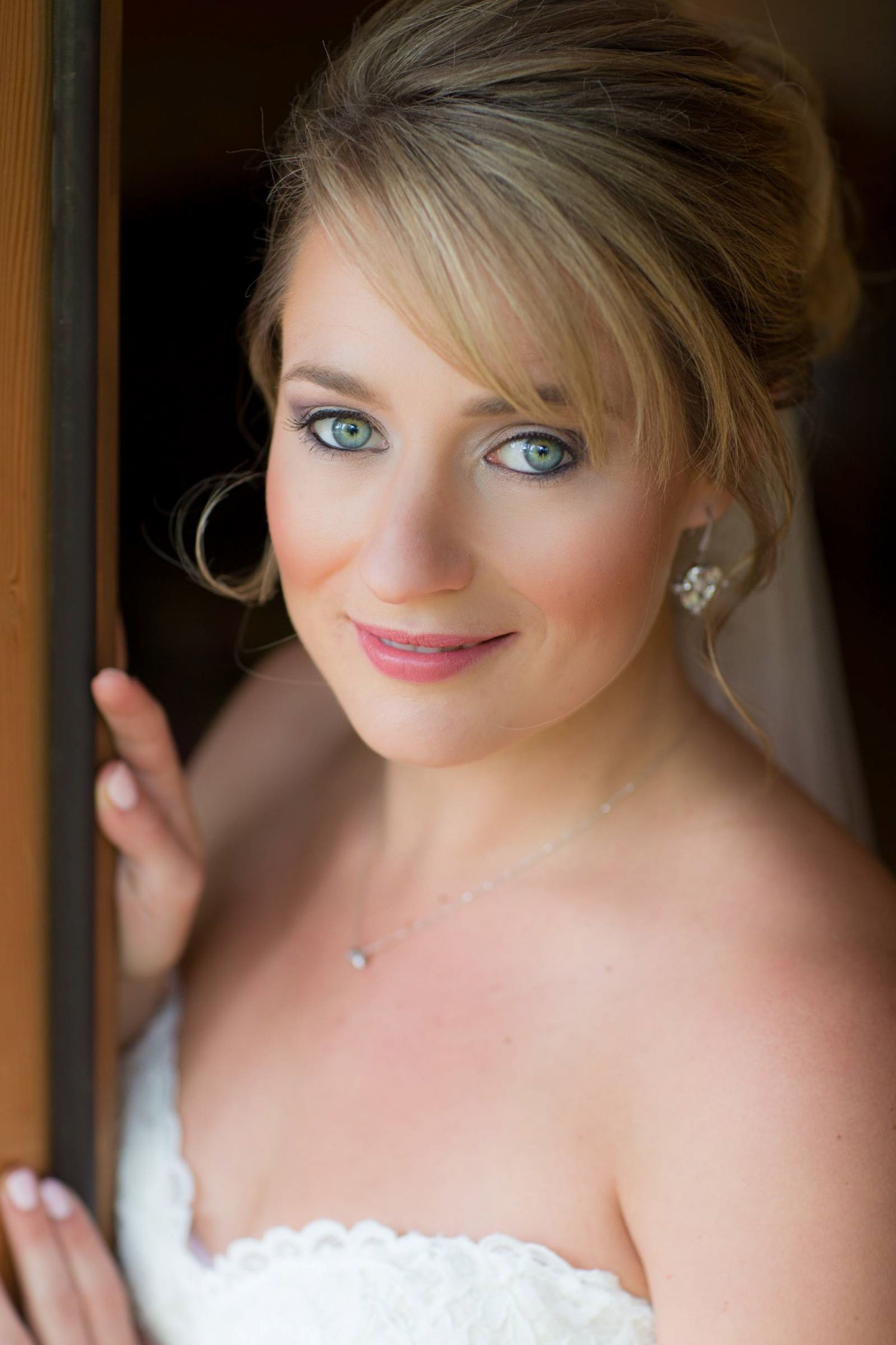 Close-up portrait showcasing elegant bride and jewelry with soft lighting and warm tones in Fairmont Hot Springs, BC