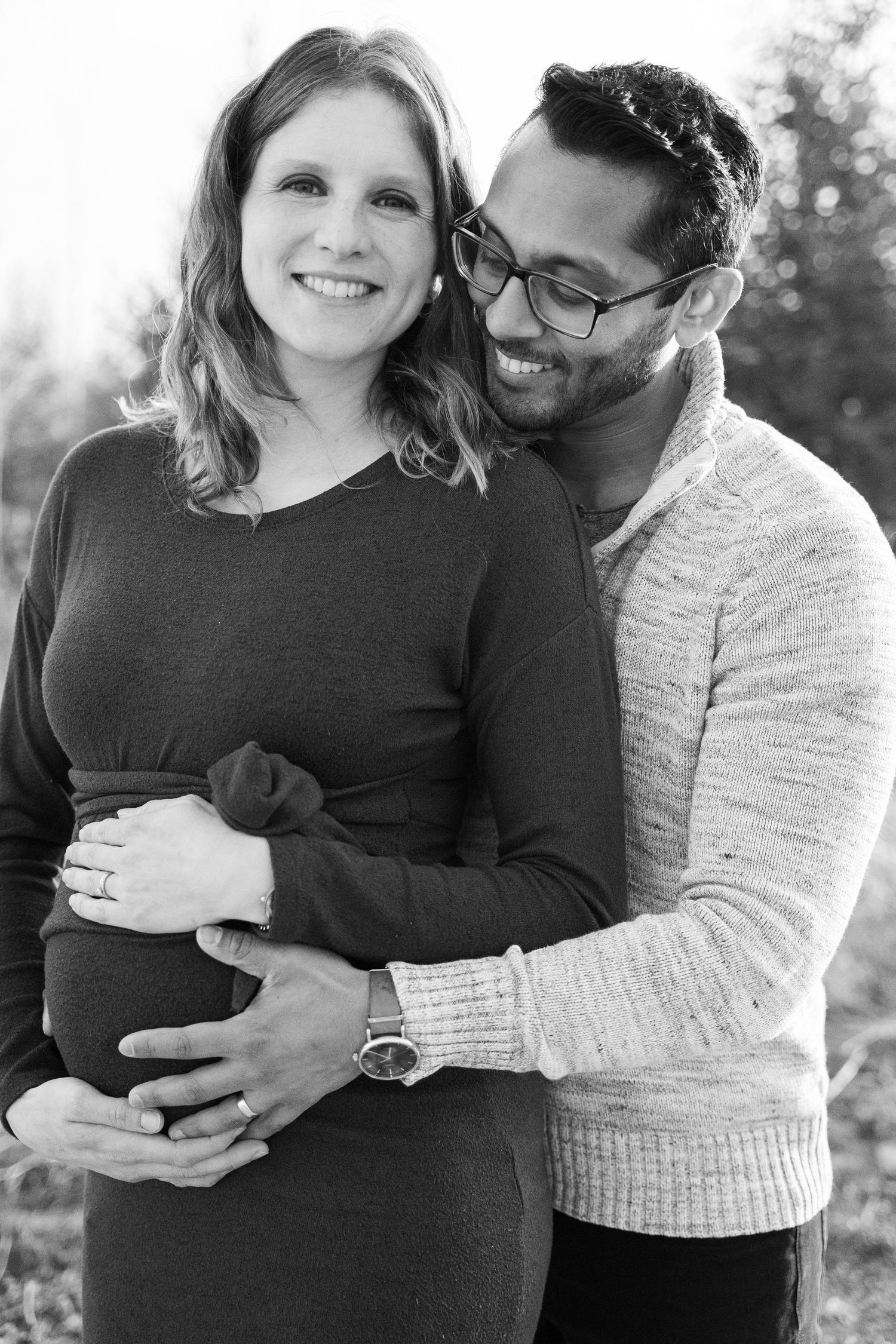 Intimate black and white maternity photo of couple embracing.