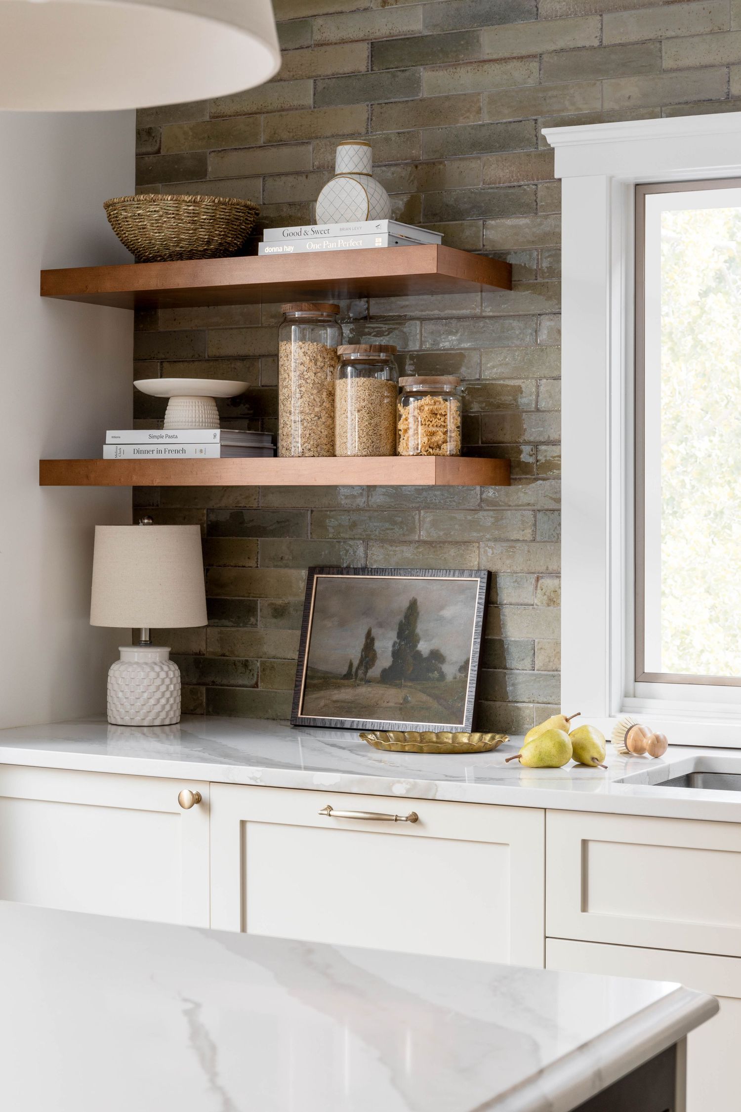 White kitchen with floating wood shelves, stone tile accent wall, and marble countertops.