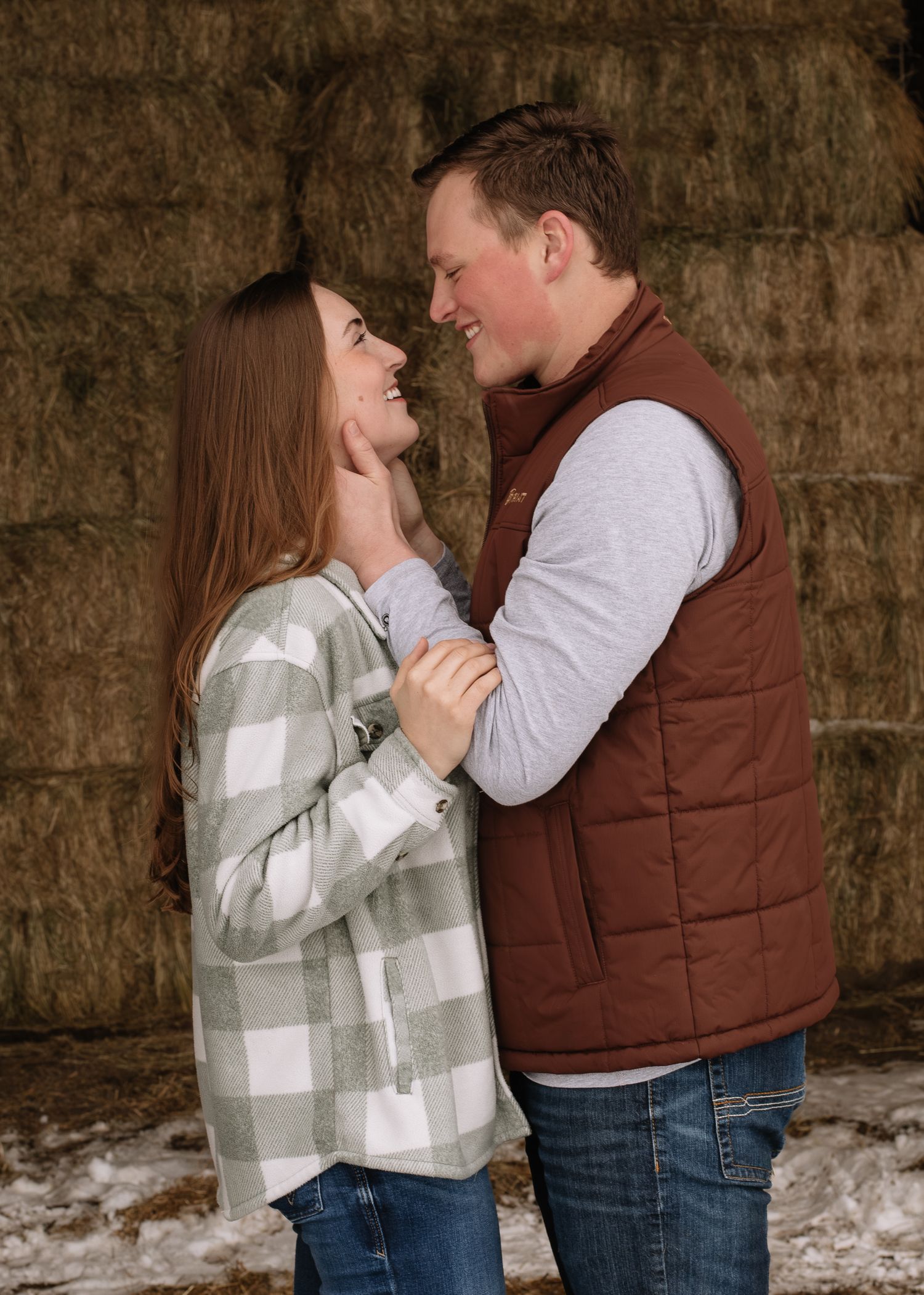 A couple in winter attire shares a romantic moment against a stone wall backdrop in a sequence of candid photos.