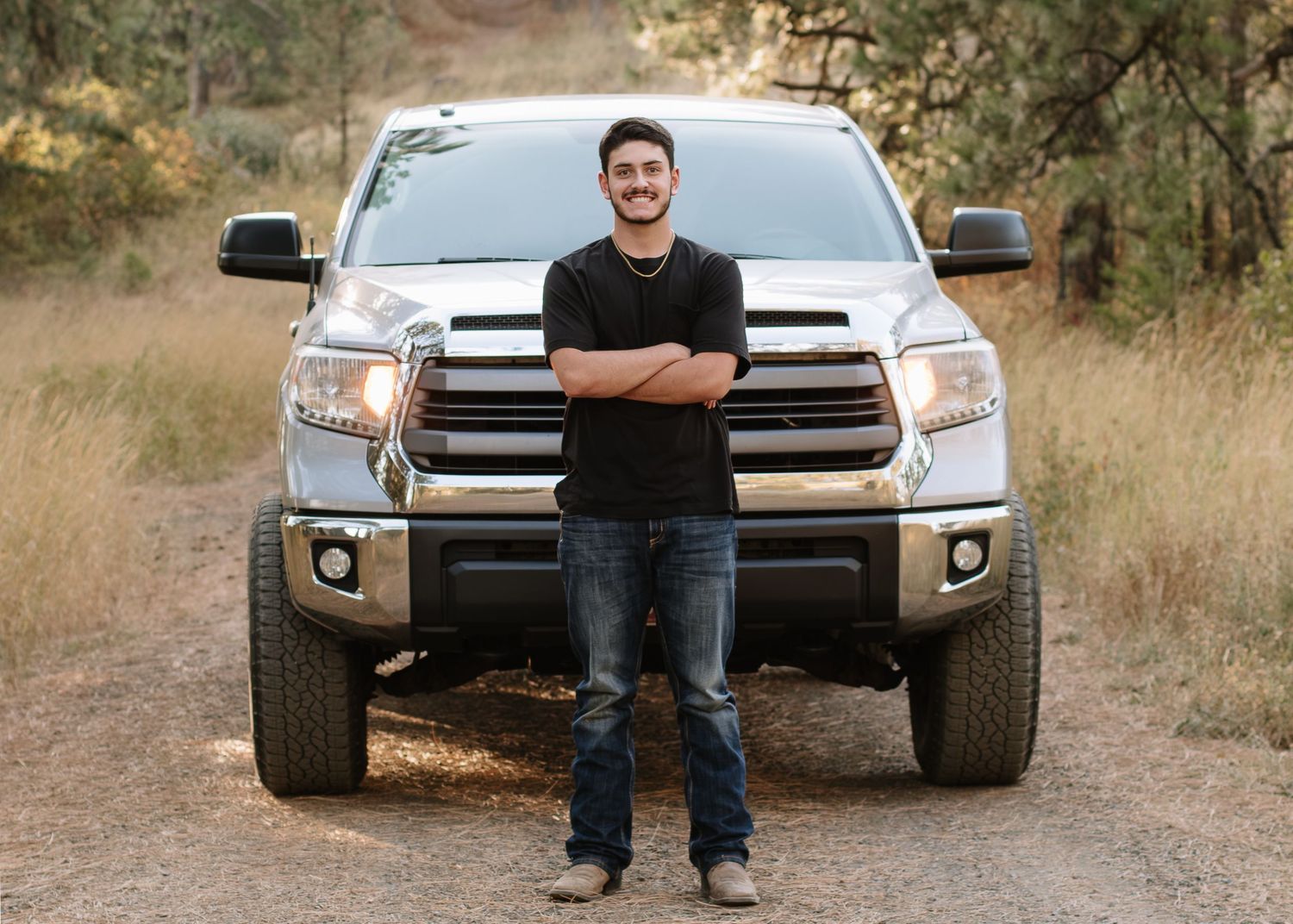 Four sequential outdoor photos showing someone posing with a silver pickup truck in a rustic natural setting.