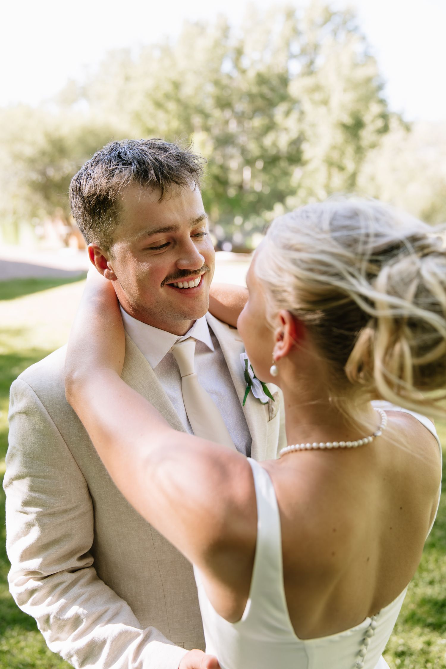 A romantic series of wedding photos showing a couple sharing intimate moments and laughter in natural outdoor lighting.