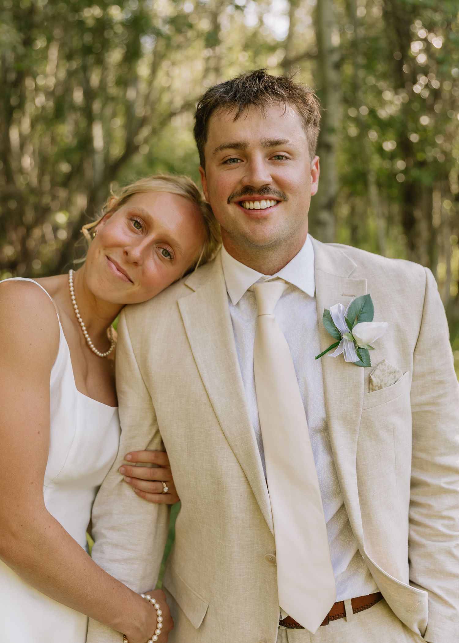 A couple in wedding attire share intimate moments in a series of outdoor photos with natural lighting and greenery.