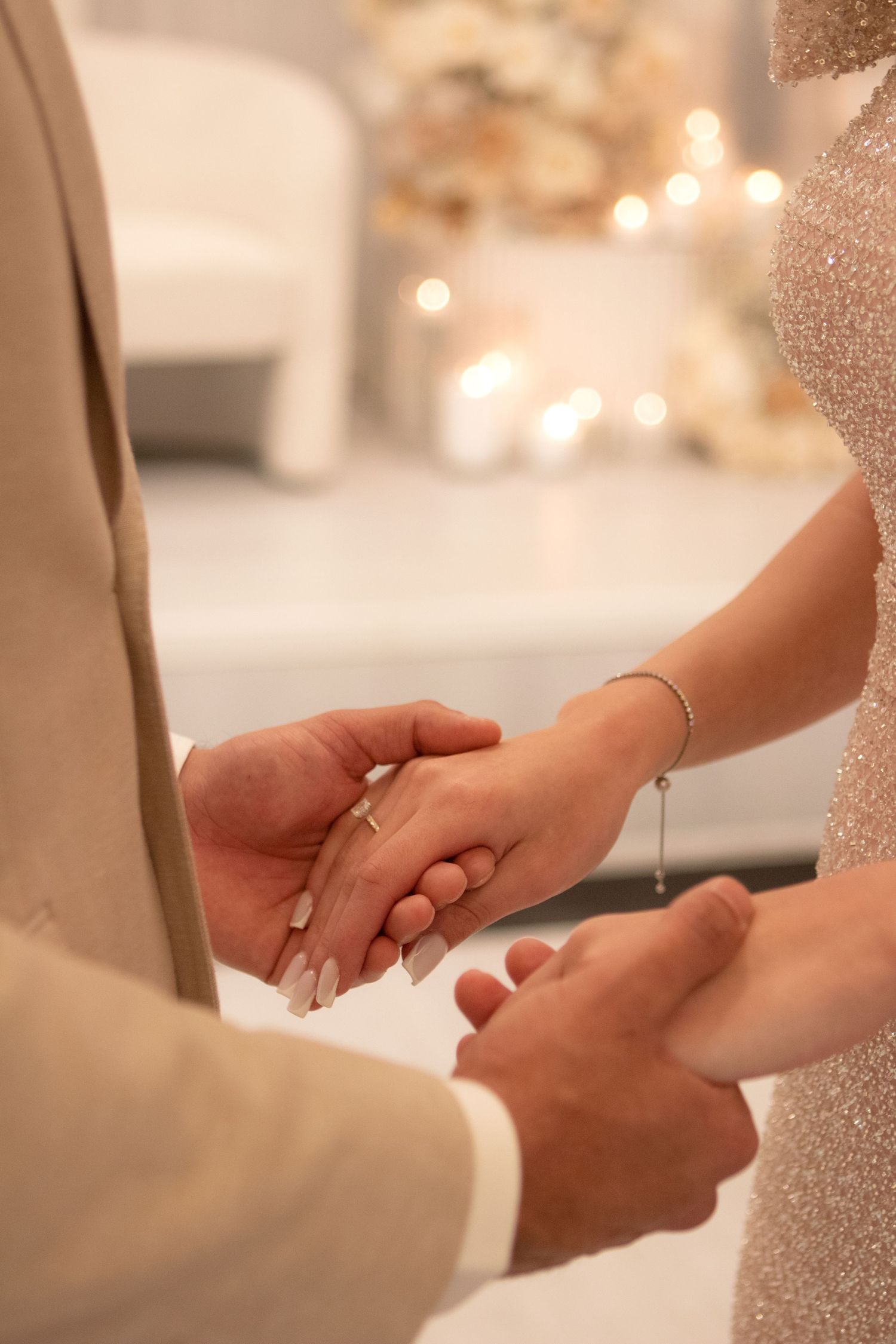 Close-up shots of hands holding each other during a romantic ceremony.