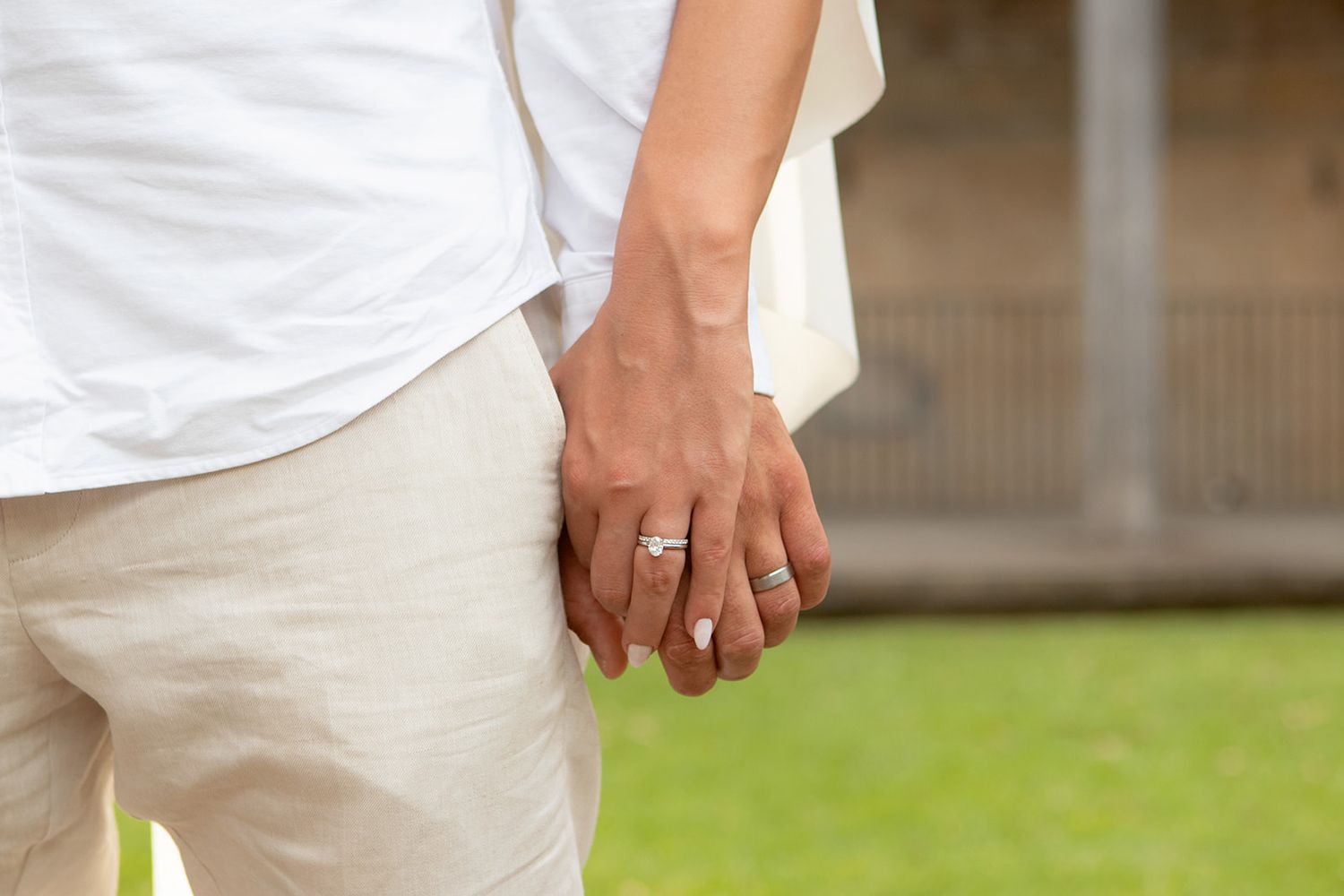 Close-up views of formal white attire and joined hands in natural lighting.