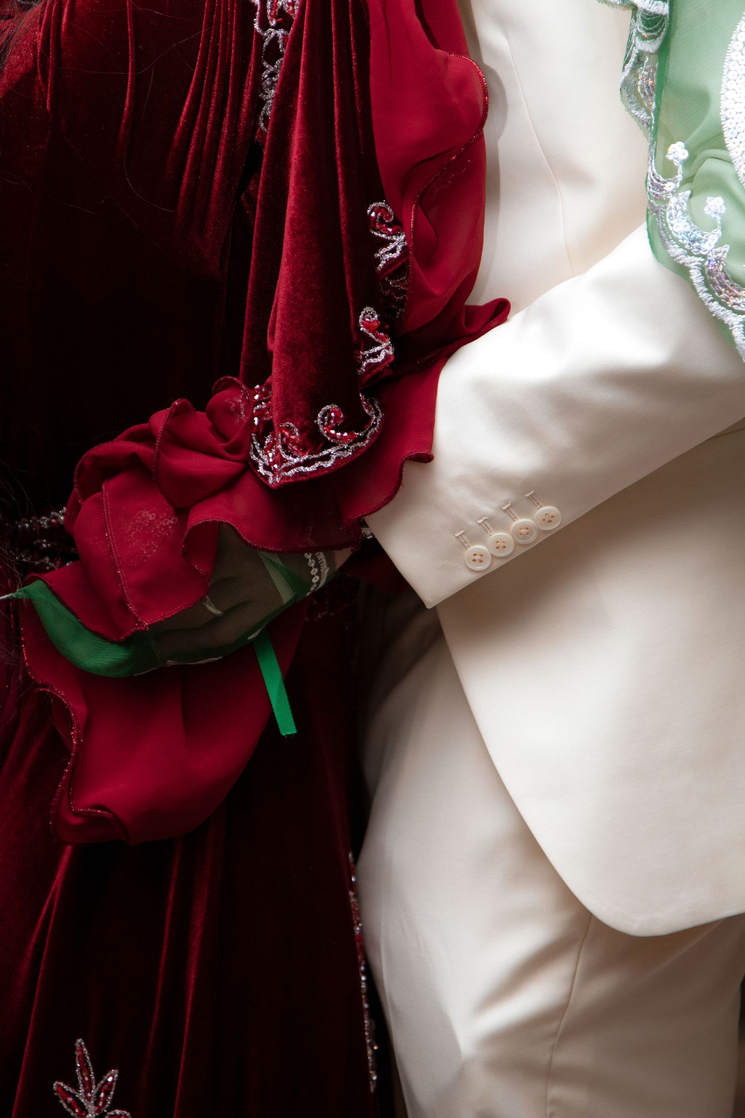Detailed shot of red velvet and white fabric with decorative embellishments.