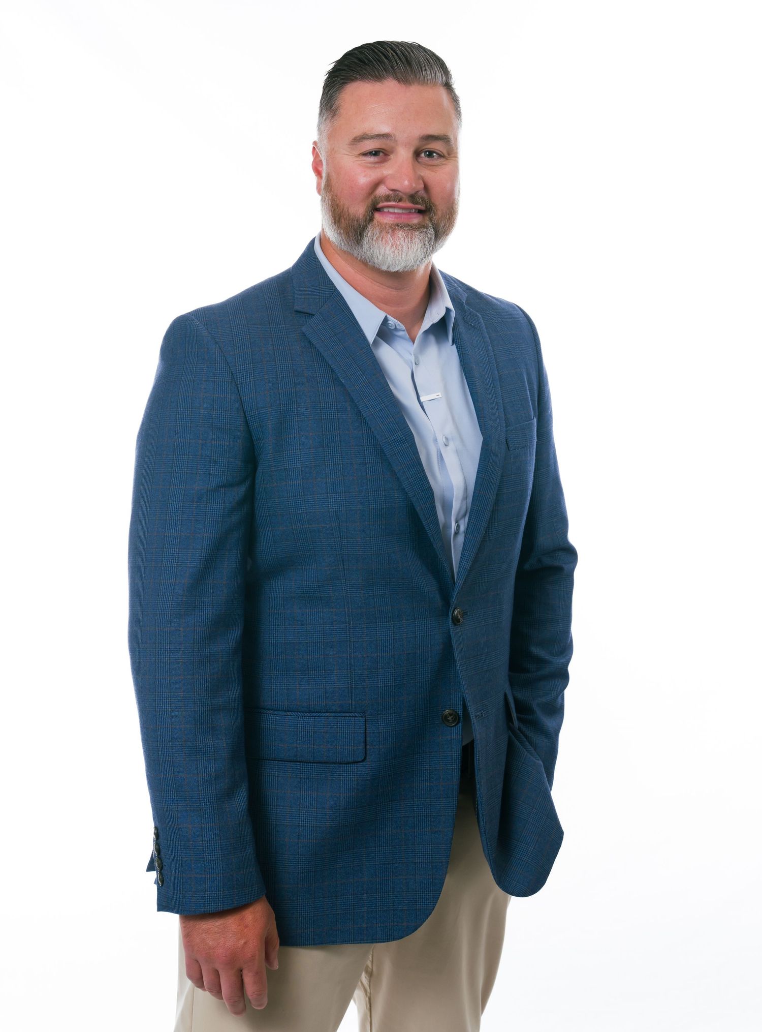 Professional portrait of a person wearing a navy blue blazer and light gray dress shirt against white background.