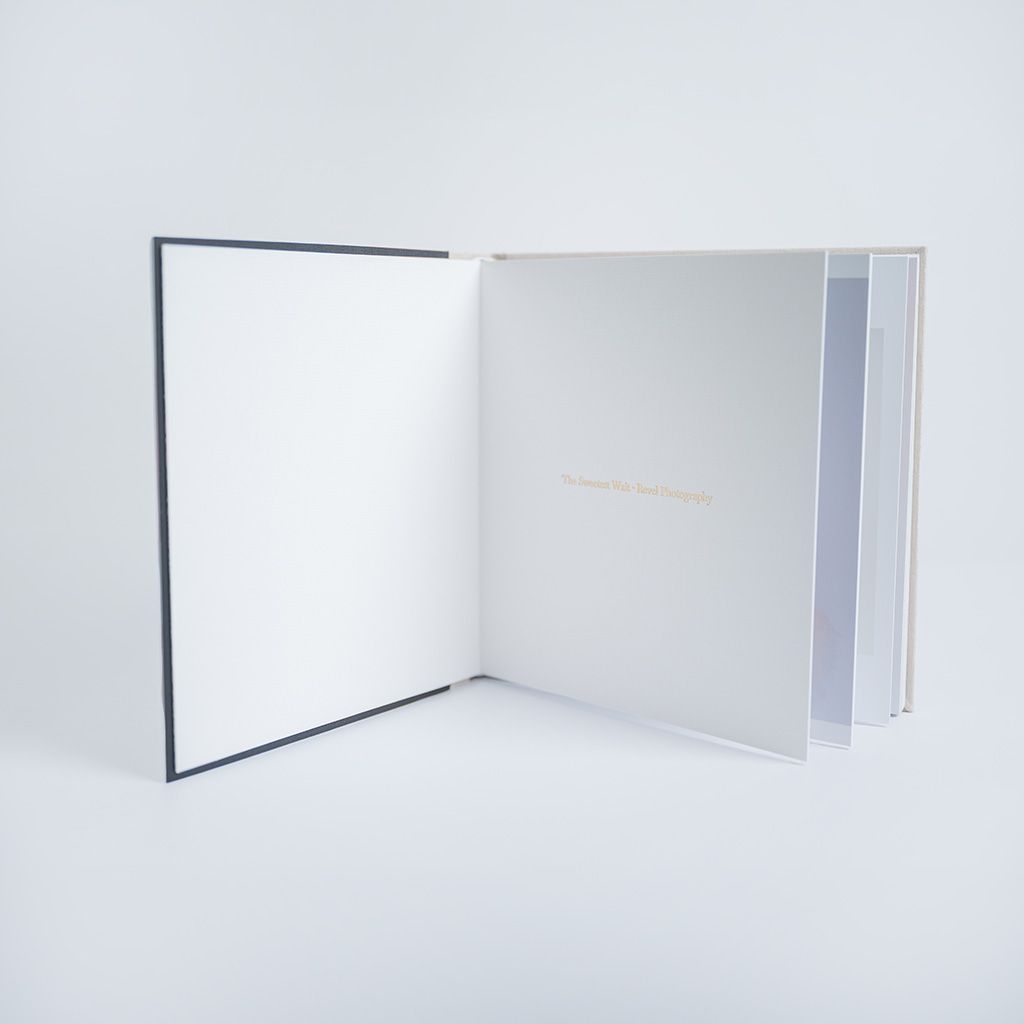 Open hardcover book with white pages and navy blue cover, displayed against a white background.