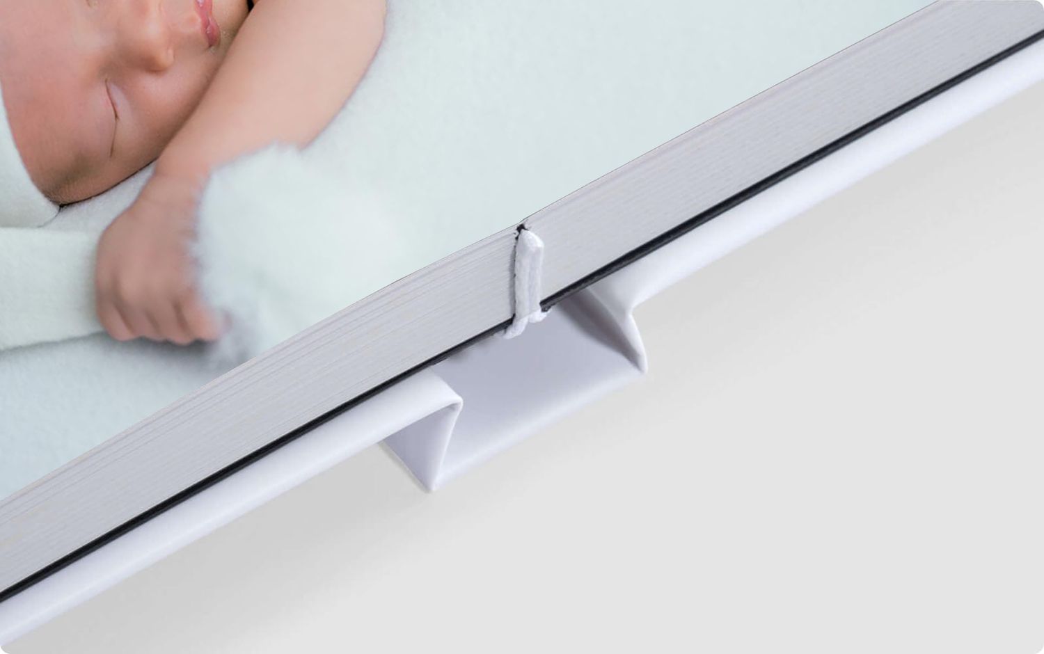A white L-shaped table edge trim piece being installed onto a flat surface.