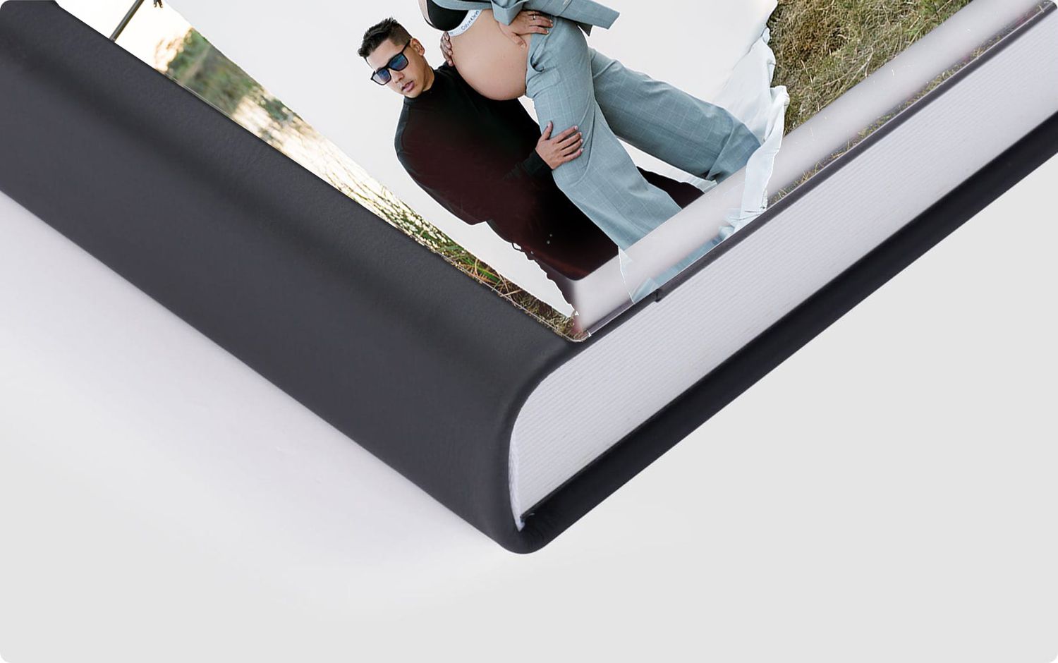 Two hands hold open a white book or journal, demonstrating how its pages softly turn in a sequence.