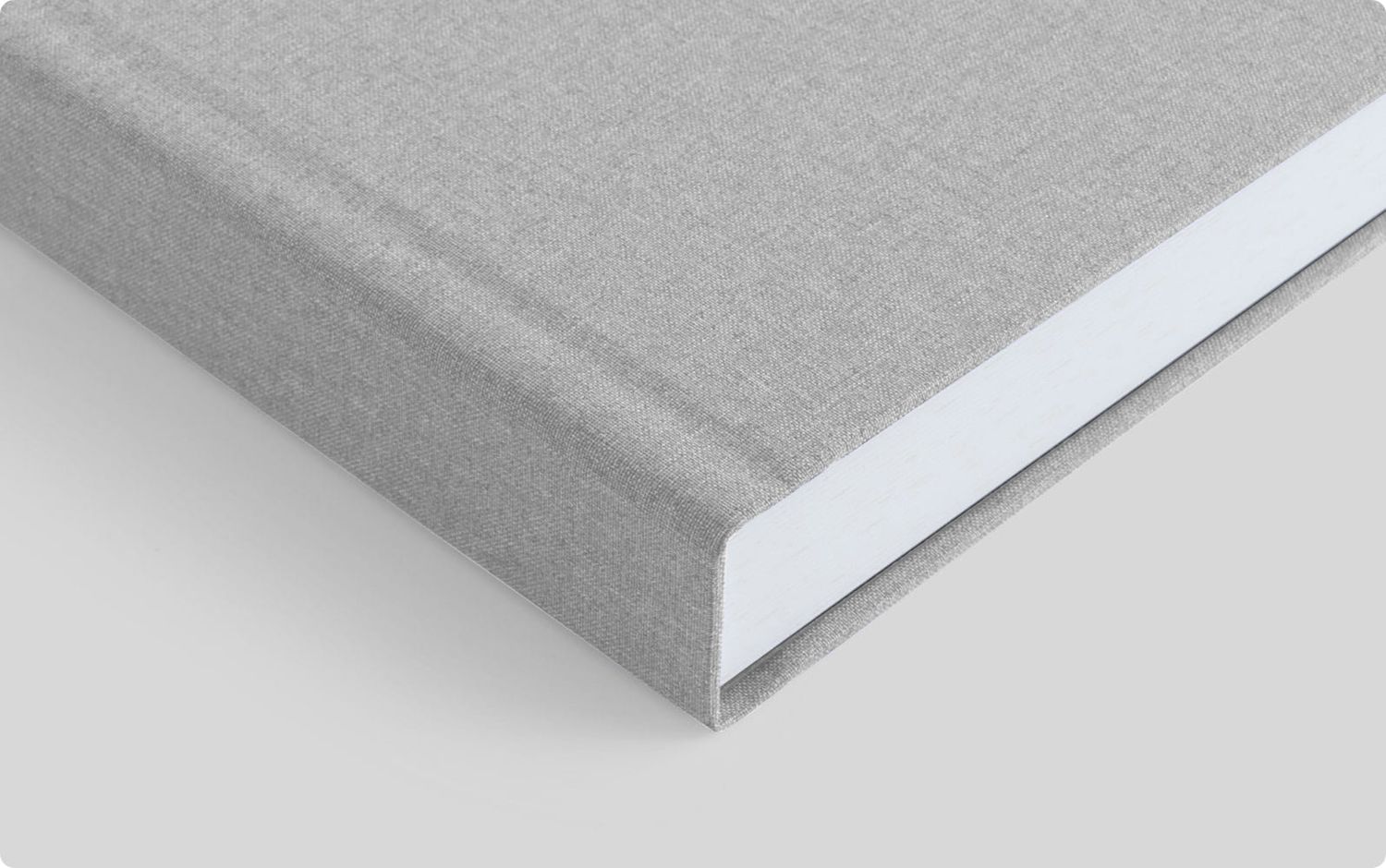 Close-up view of a light gray book cover with clean edges and minimalist white binding design.
