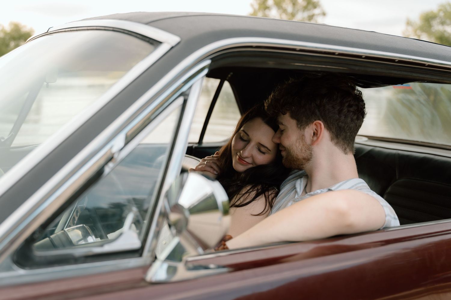 Romantic engagement photos featuring a vintage car at Lake Monroe in Bloomington, Indiana.