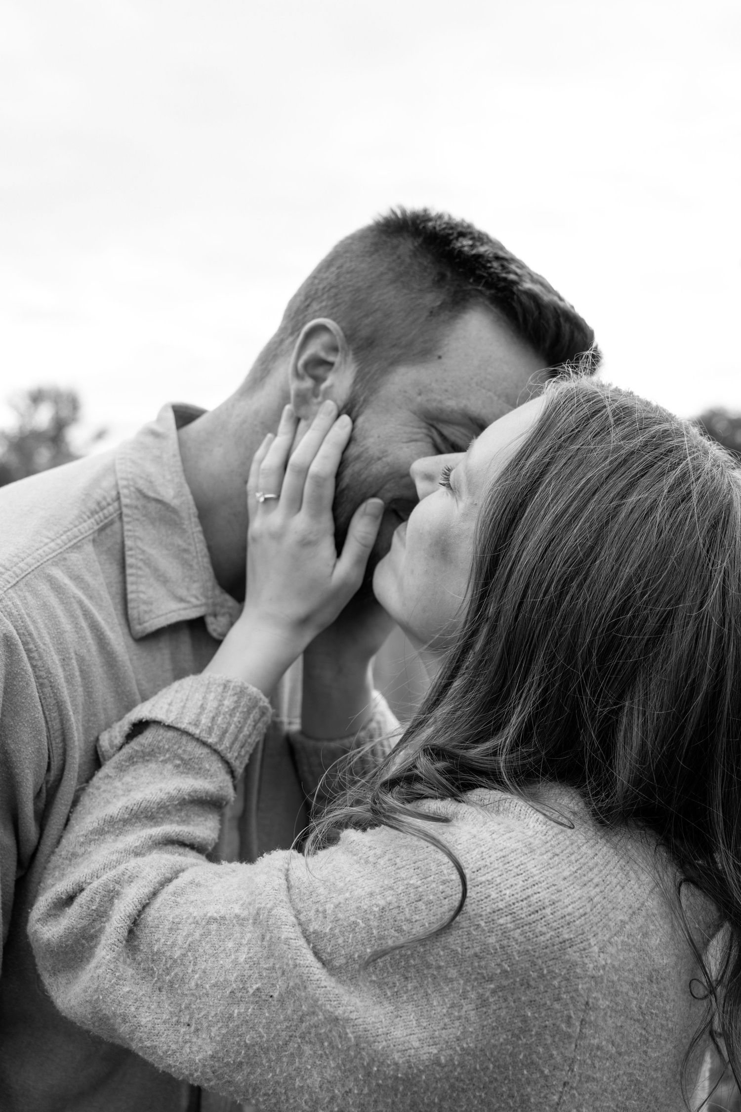 Black and white photo of a couple sharing an intimate moment, woman cradling mans face.