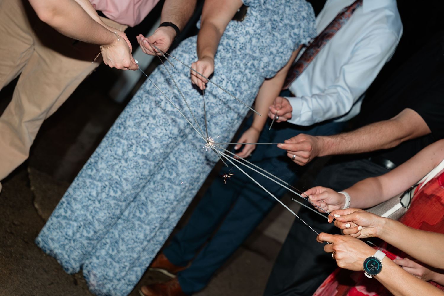 Guests pulling strings on a blue floral dress at a wedding reception celebration.