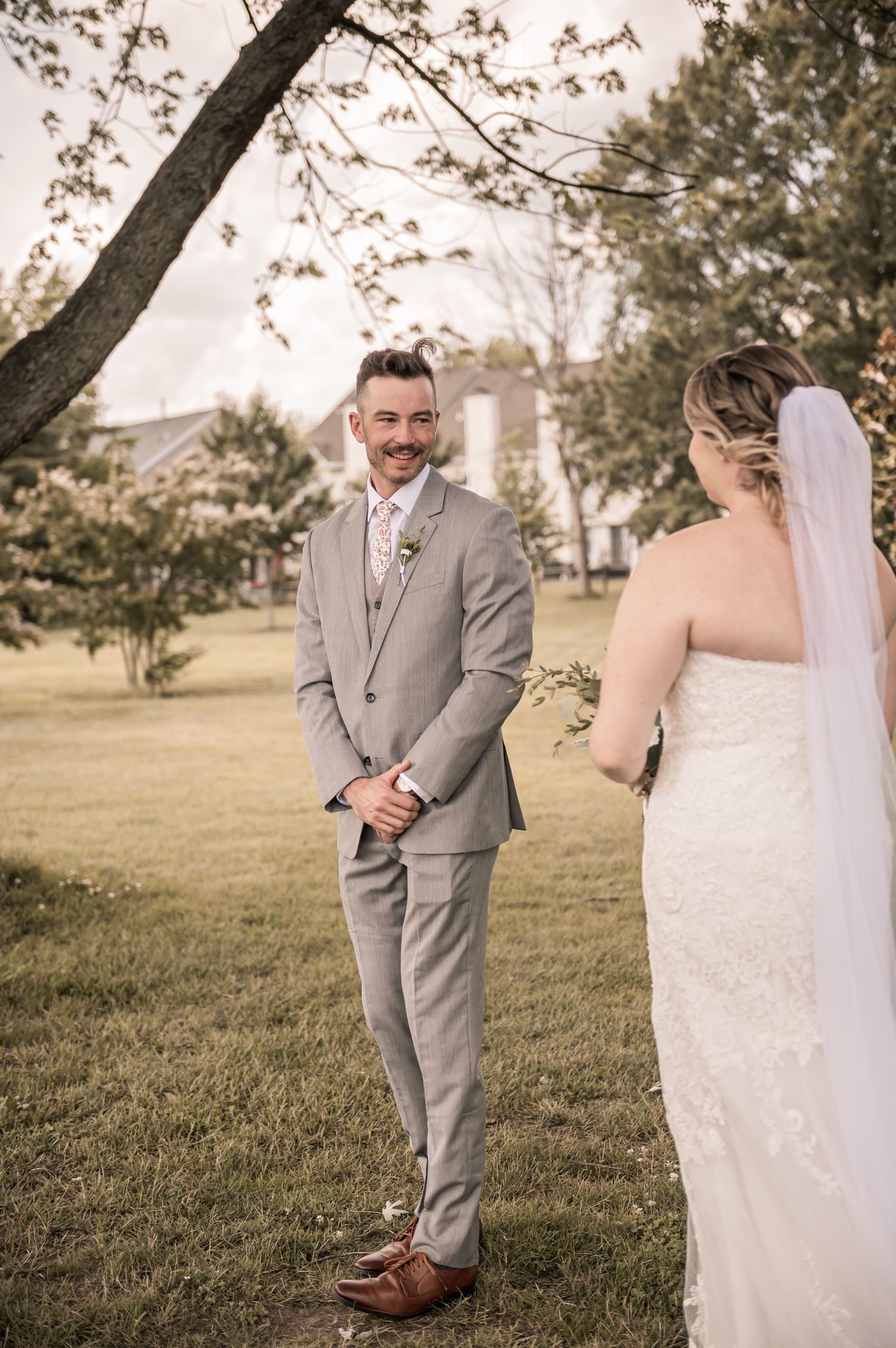 A bride and groom share a lighthearted moment together outdoors during their wedding photoshoot.