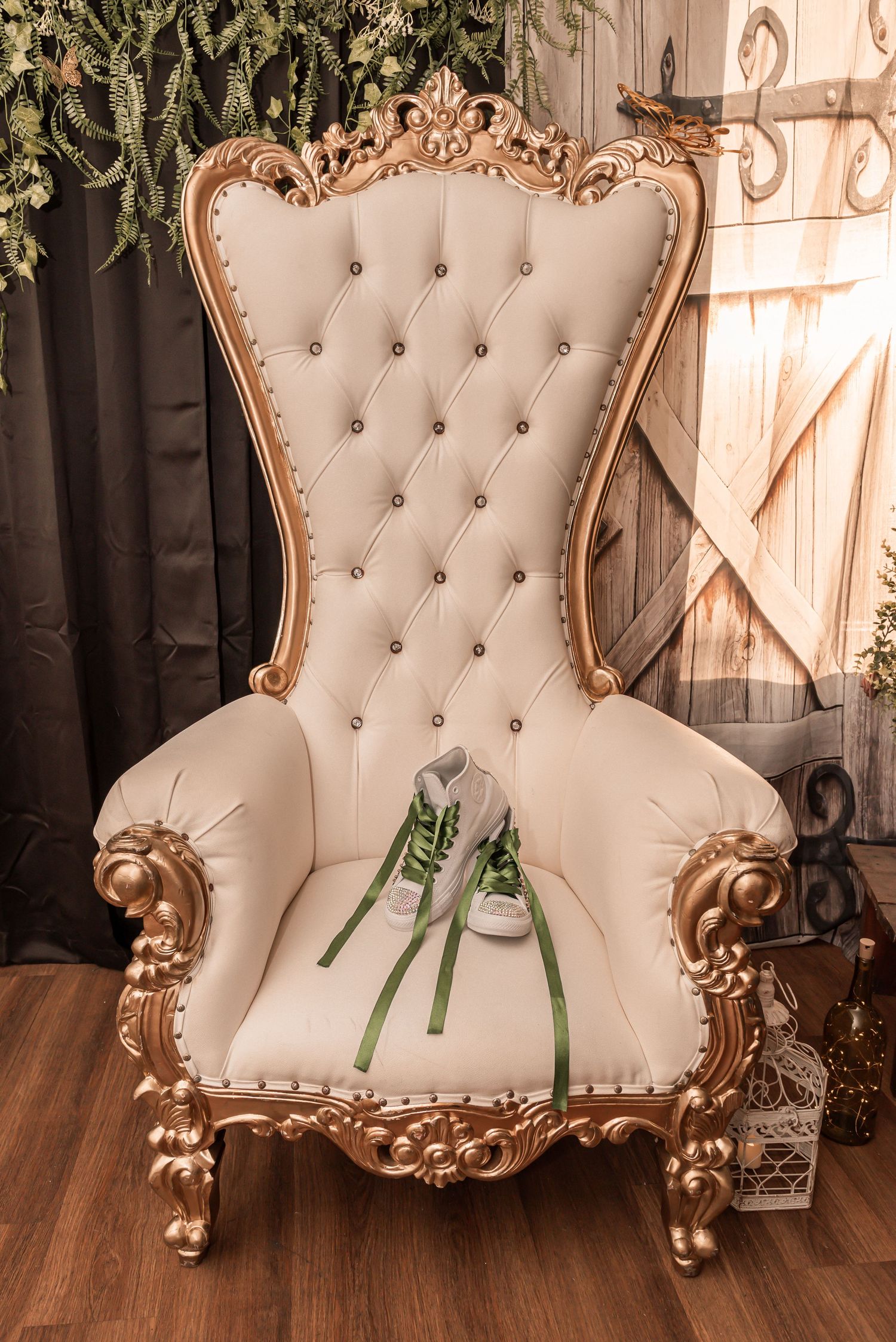 Ornate white and gold tufted throne chair displaying green and white sneakers with ribbon bouquet for quinceañera.