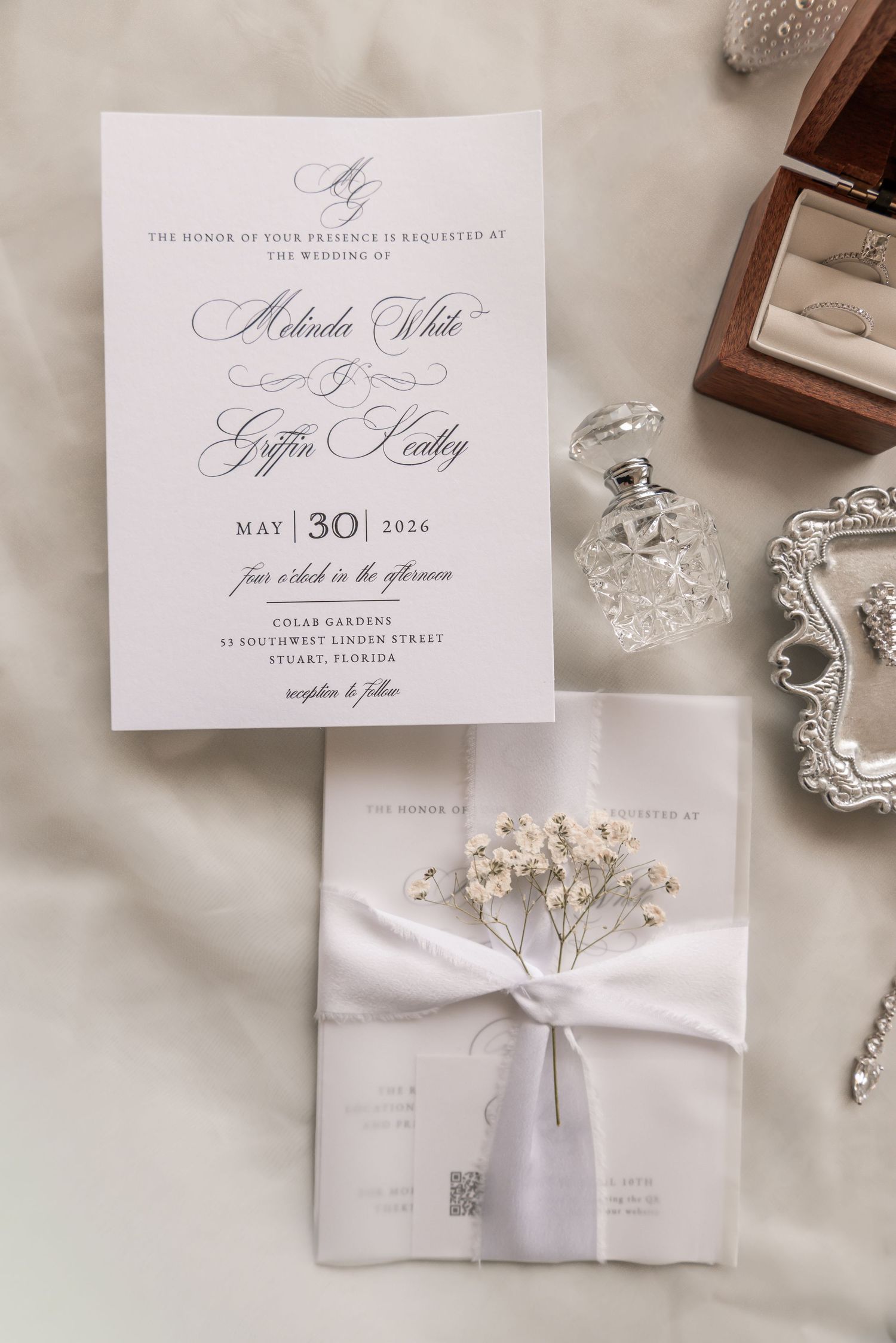 Elegant wedding invitation suite for Mikaela White and Griffin Headley, May 30 2026, with floral vellum wrap and ribbon.