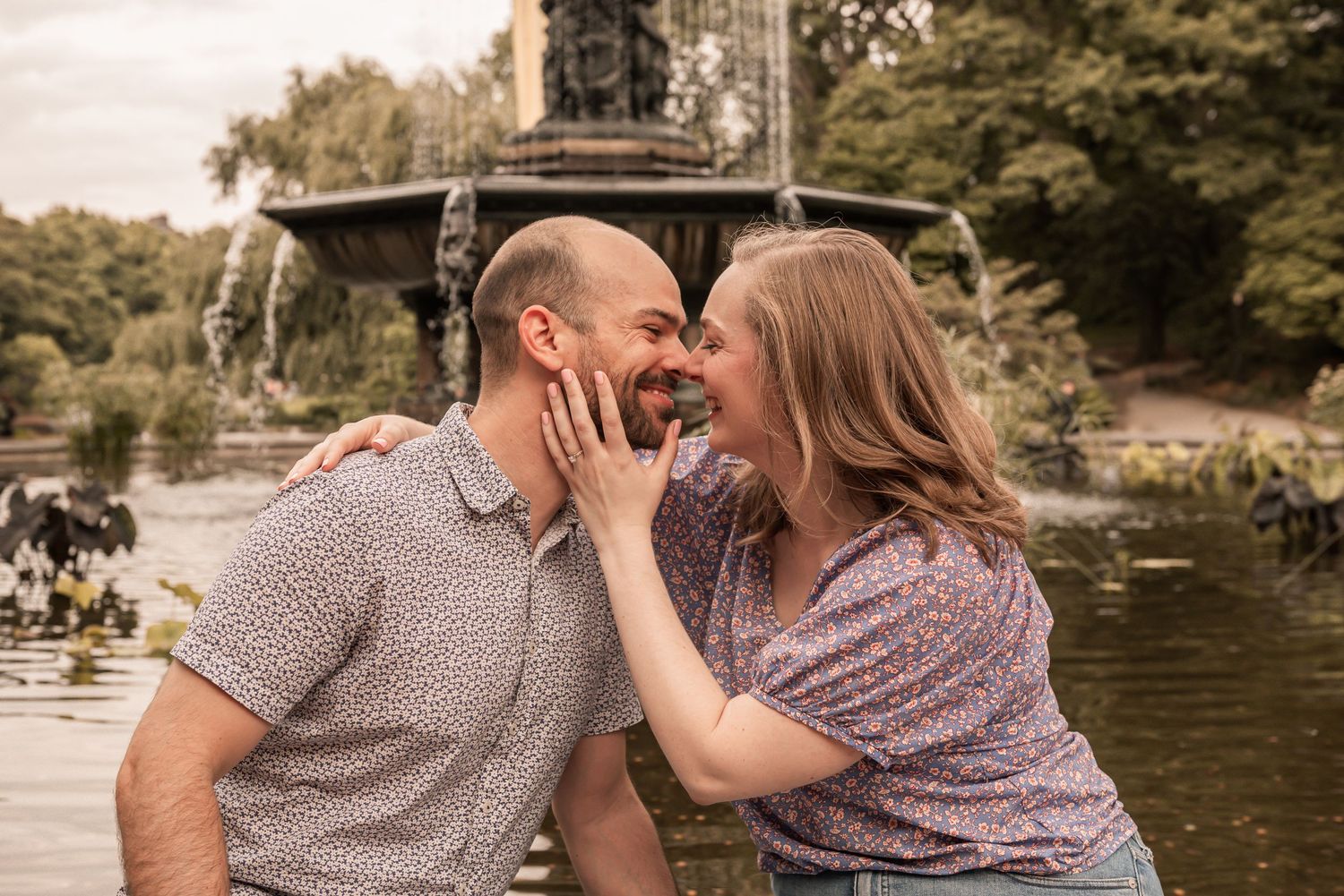 Couple sharing romantic moments by a serene lake on a warm sunny afternoon.