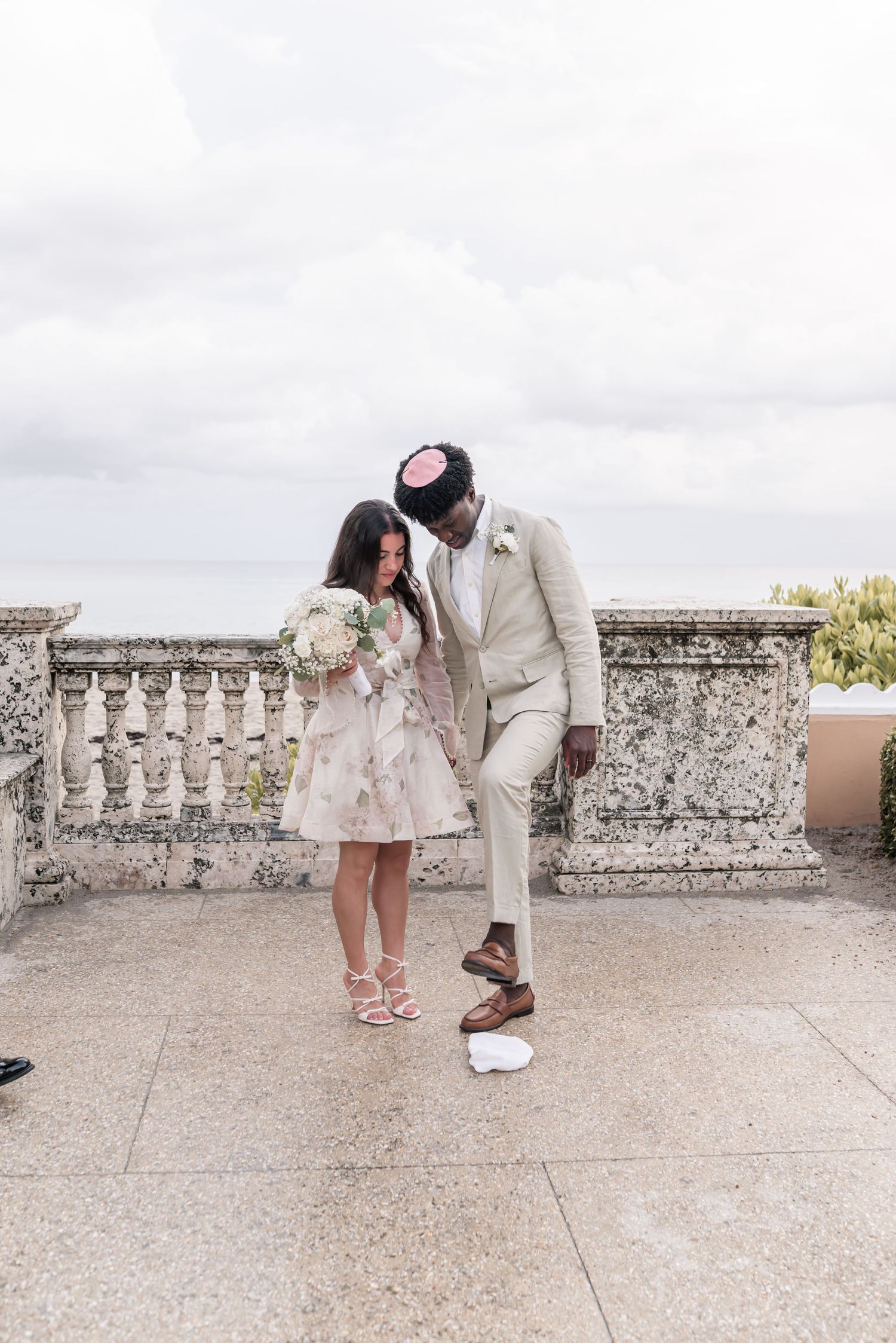 Romantic proposal moment unfolds on an ornate stone terrace with decorative balustrades.