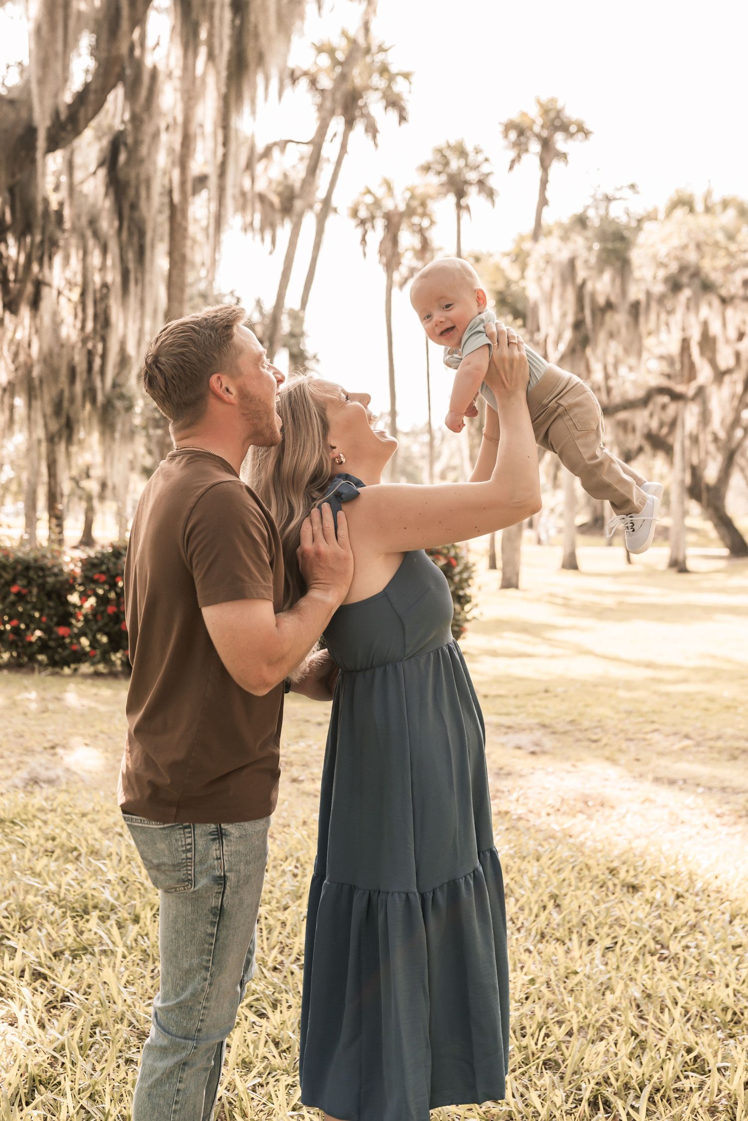 Couple dancing together under Spanish moss draped trees in a romantic outdoor setting during golden hour.