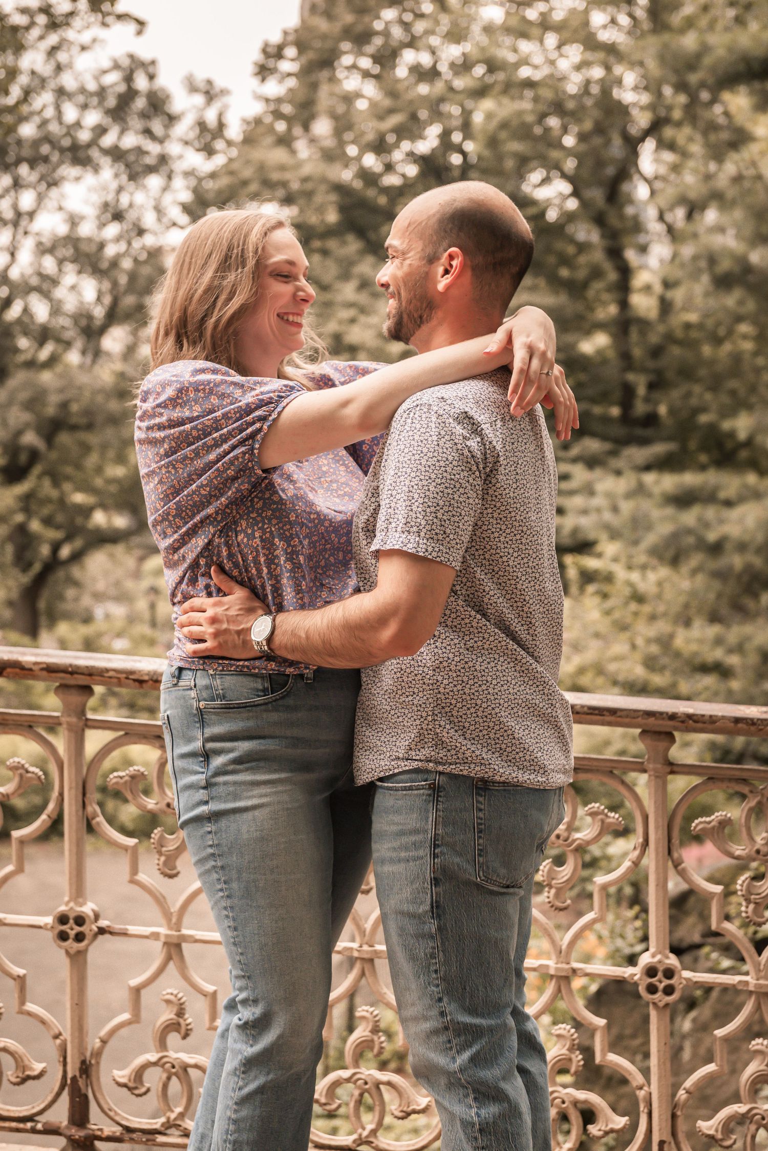 A couple shares a tender moment on an ornate balcony railing in what appears to be a vintage-style photo series.