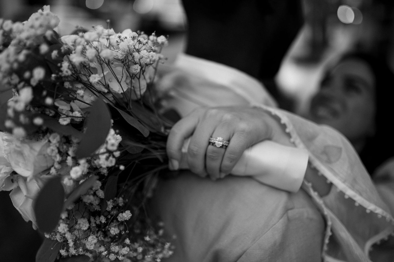 Black and white wedding photo captures intimate moments between newlyweds during their celebration.