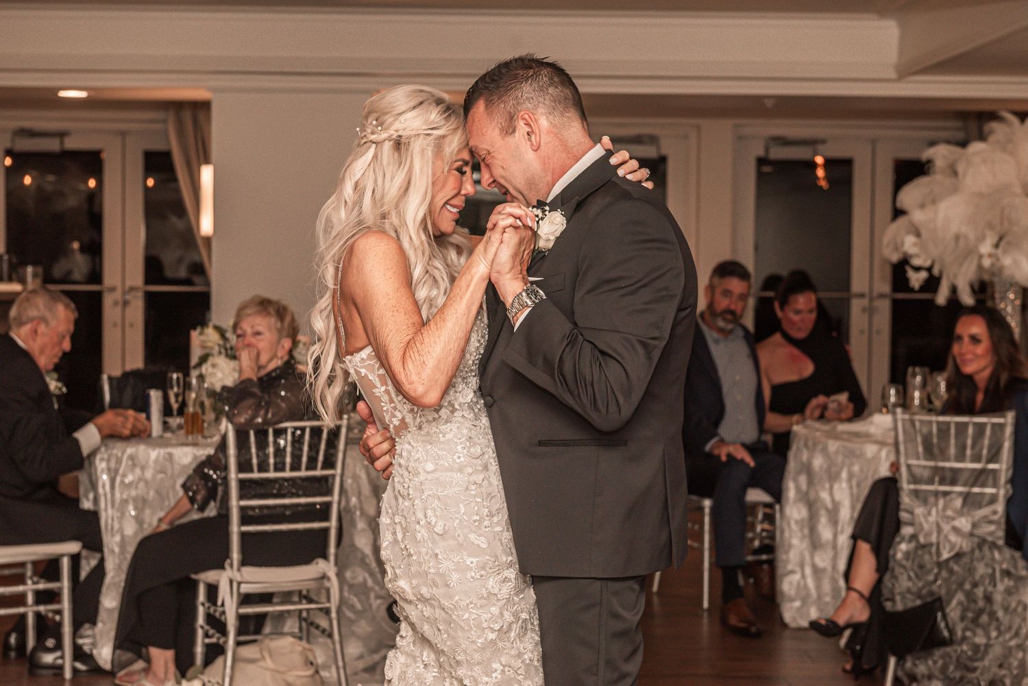 A couple shares a romantic dance together at an elegant indoor wedding reception venue.