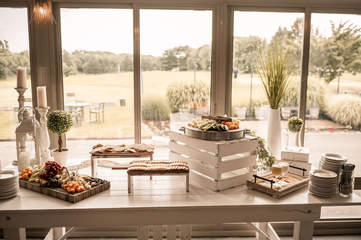 White lounge seating area with cushioned furniture and decorative table settings in an elegant outdoor venue space.