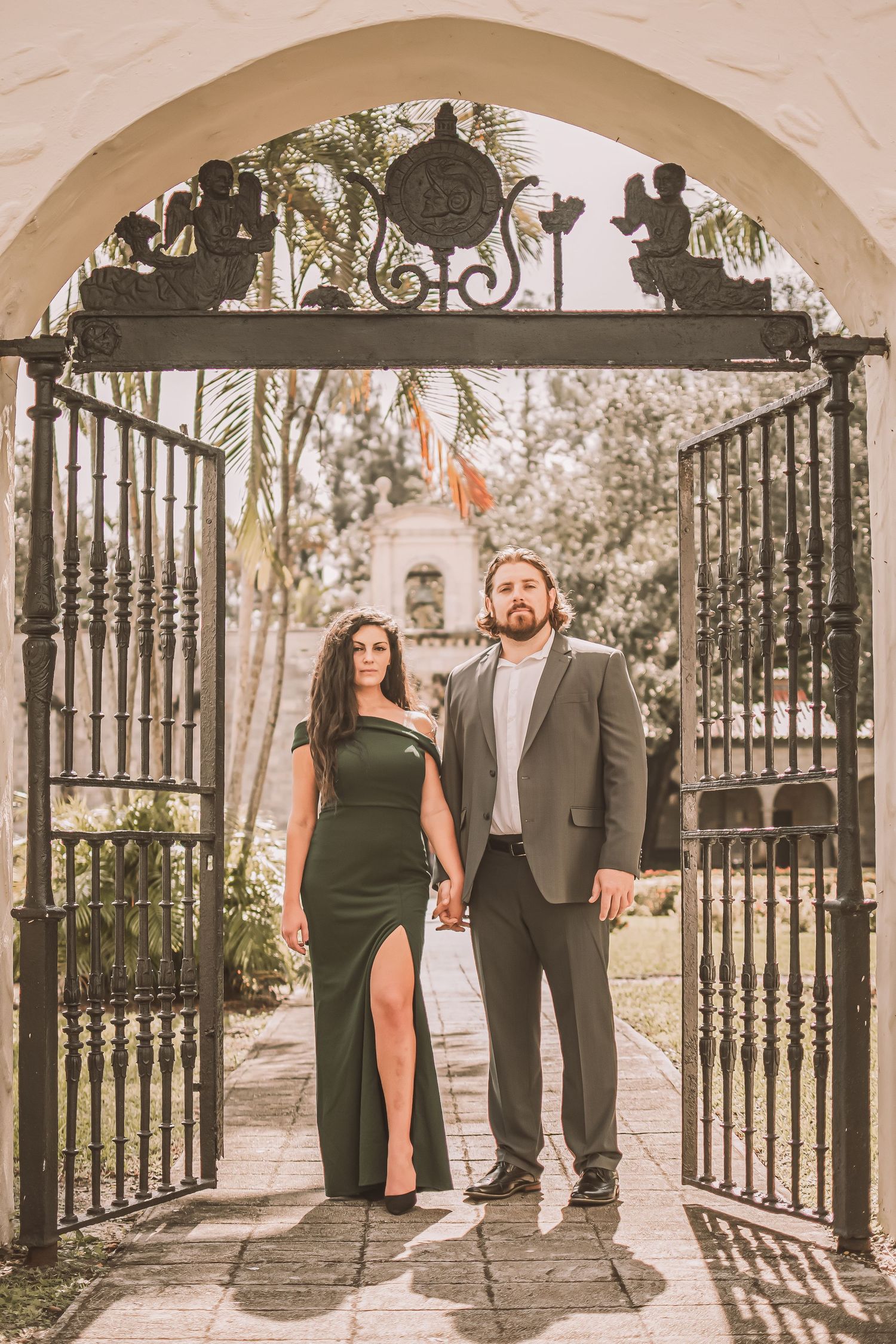 Romantic couple photo series through ornate iron gates showing silhouettes and shadows in vintage style photography.