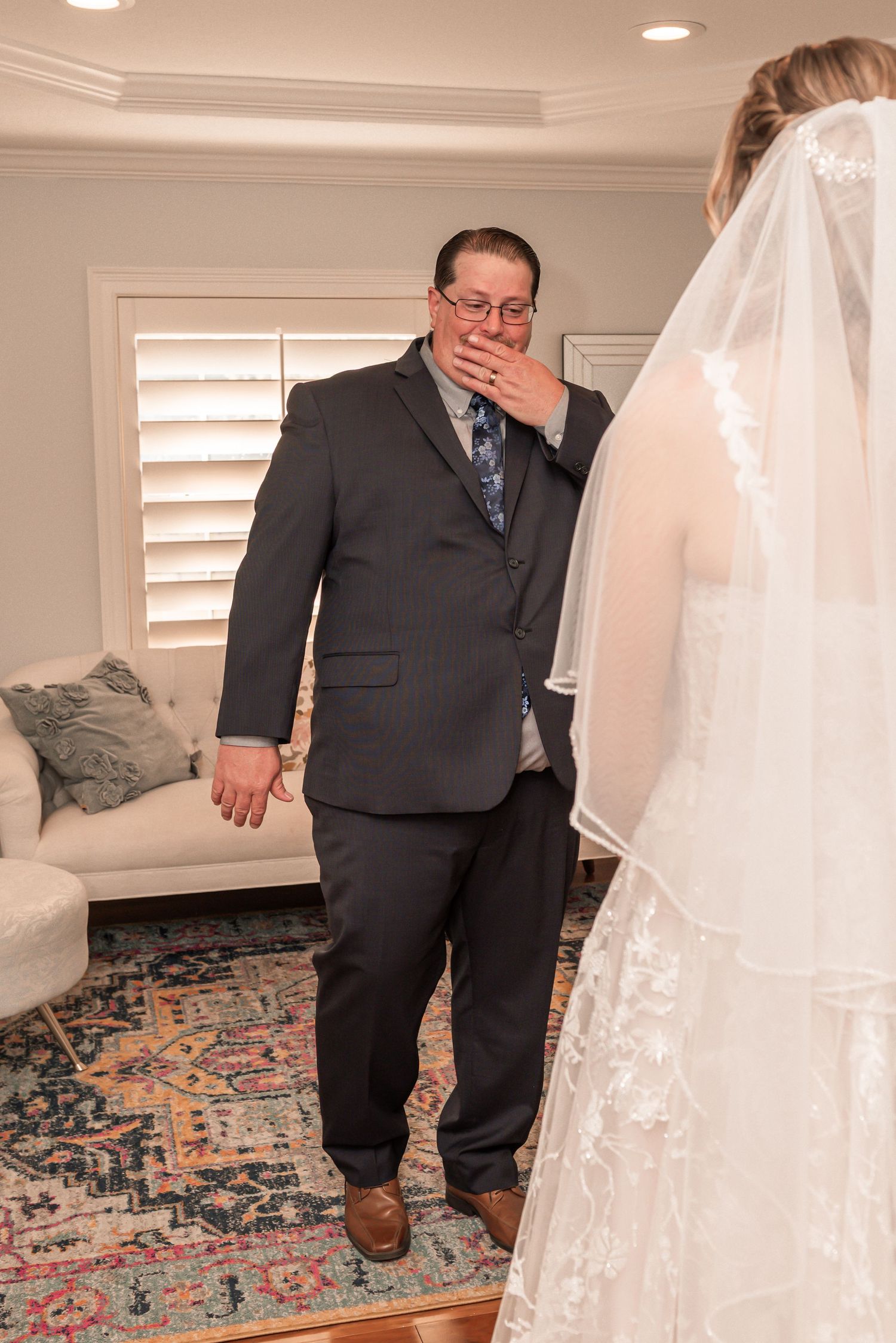 A series of photos showing someone in a dark suit reacting emotionally to seeing a white wedding dress.