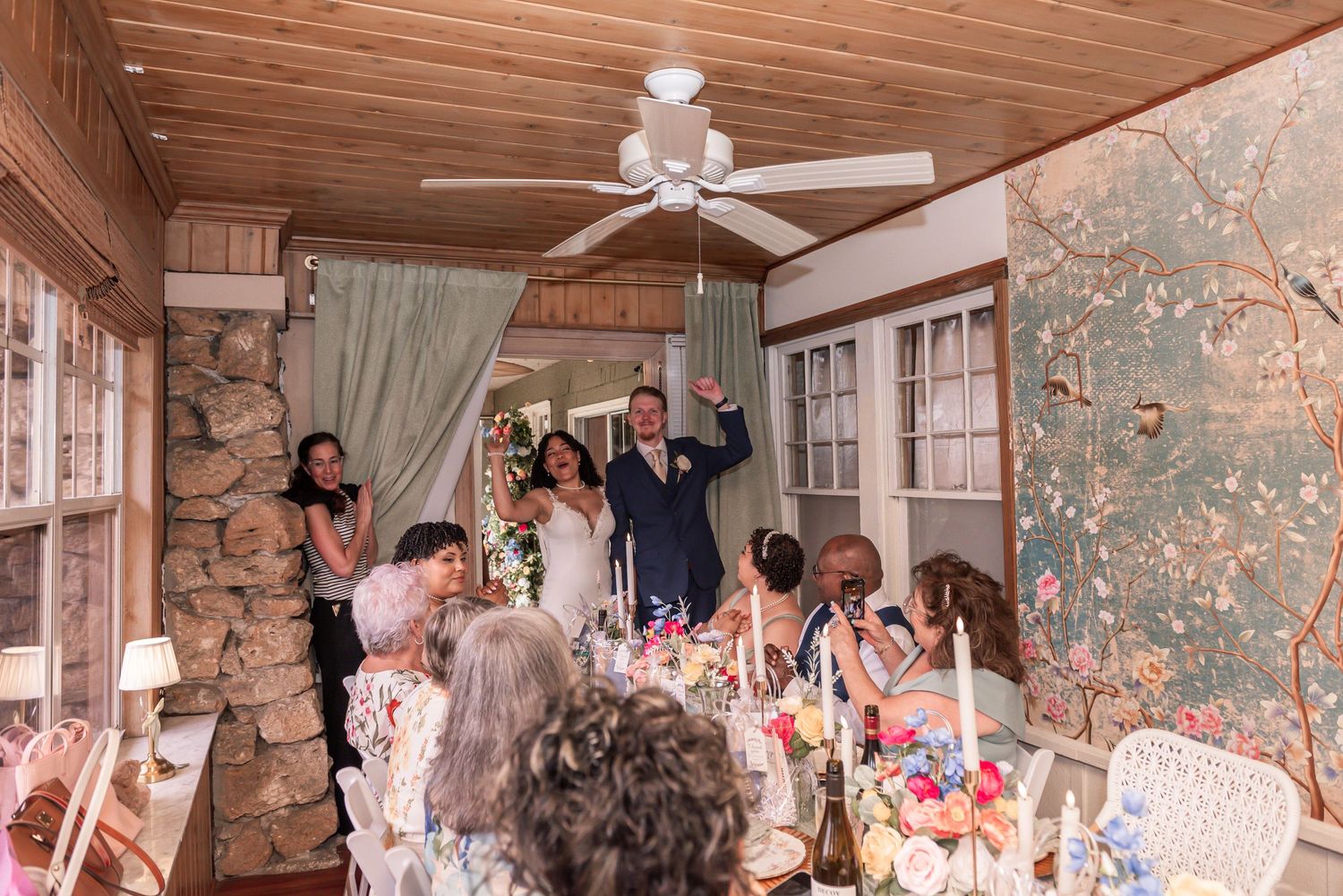 Newlyweds make grand entrance to cheering guests at intimate indoor wedding reception.