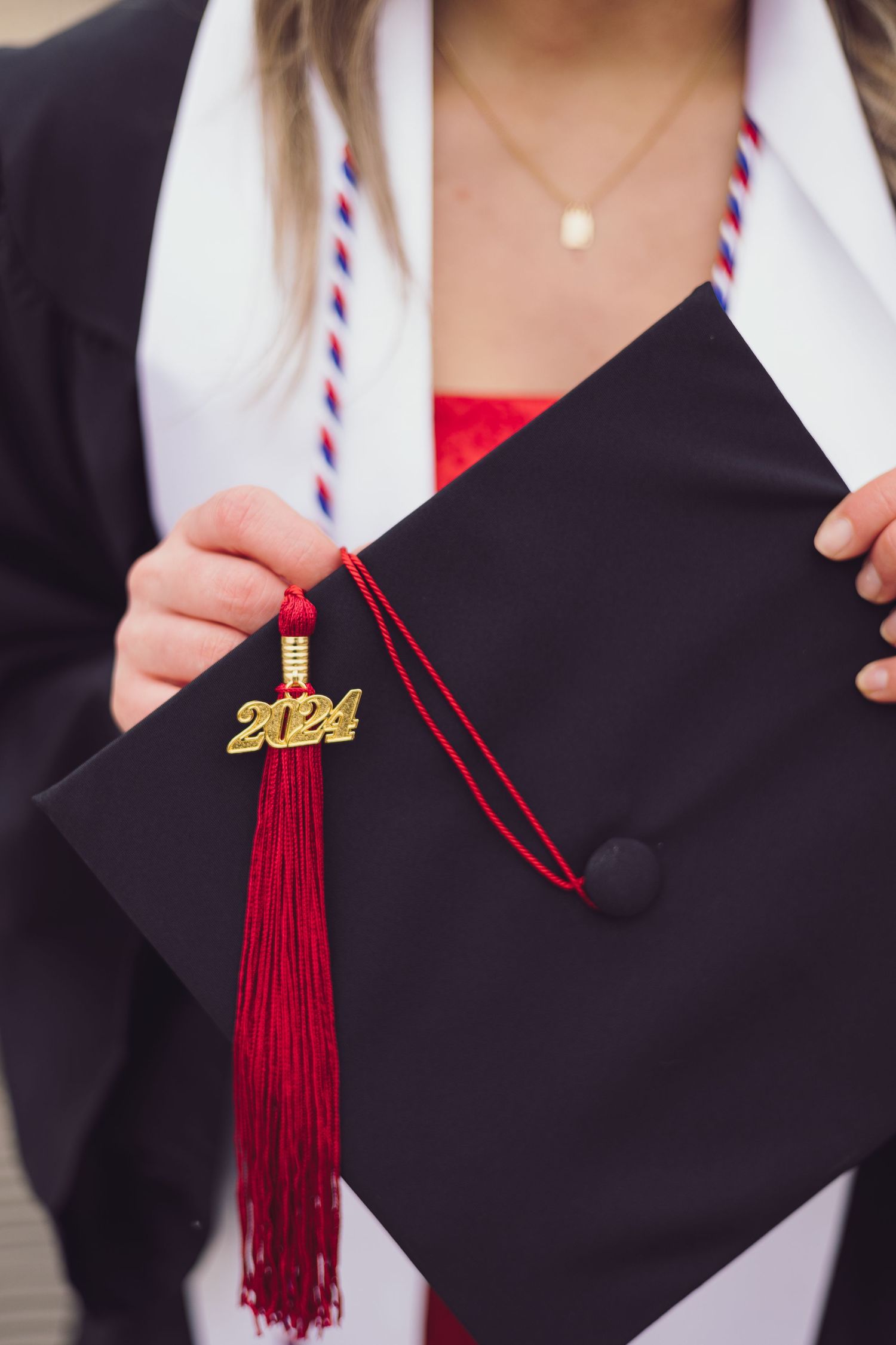 Close up of graduation cap with red tassel and 2024 charm.