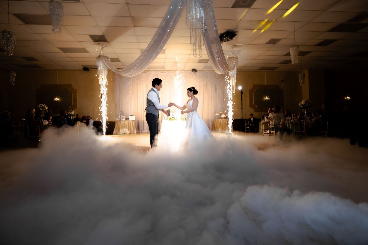 Fog machines create a dreamy atmosphere as wedding guests dance with illuminated lightsabers.