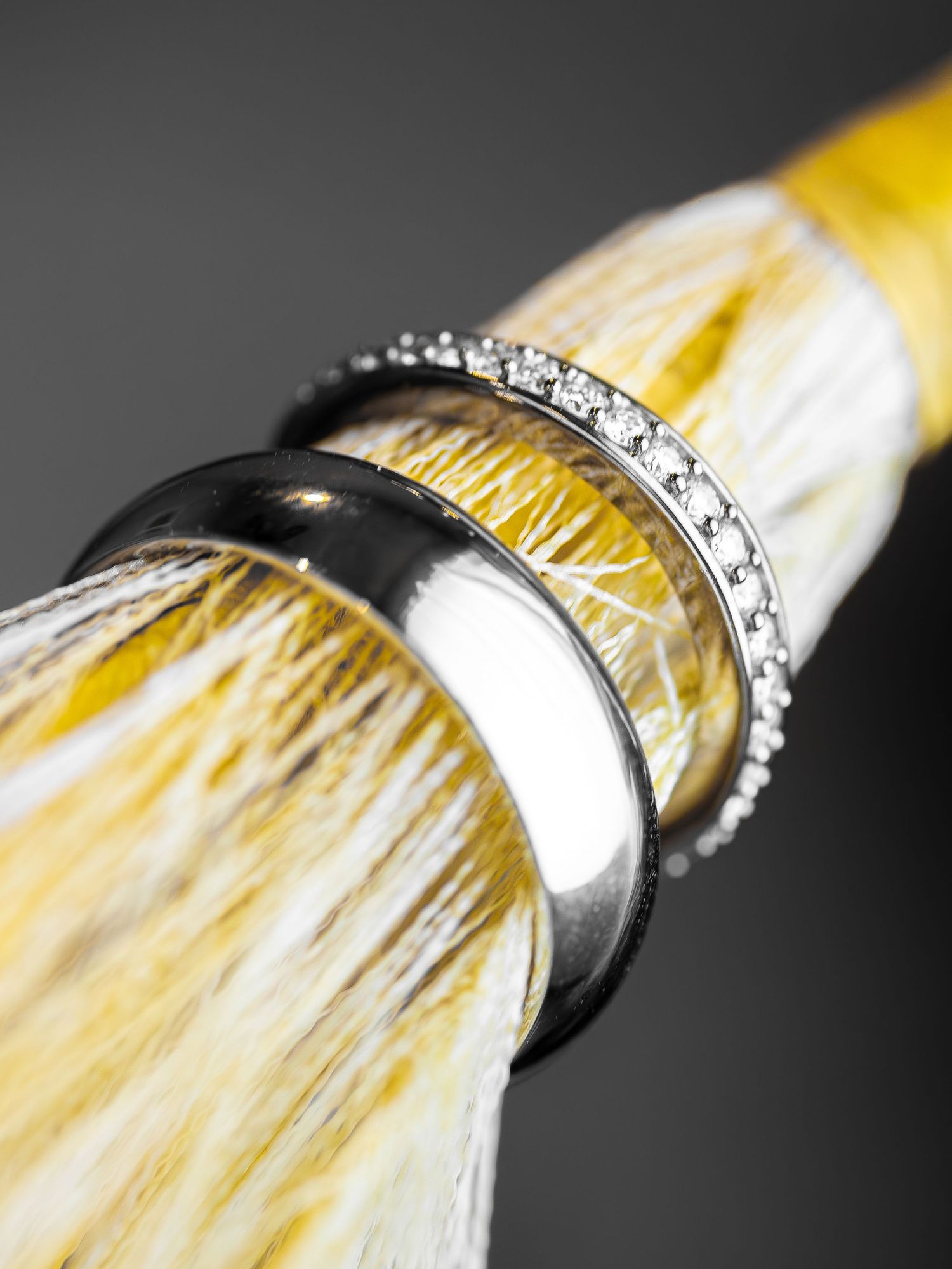 Close-up macro shots showing a yellow paint brush with white bristles and diamond embellishments in sequence.