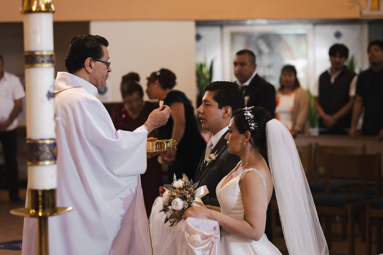 A couple dances together during a wedding reception in a warmly lit venue.