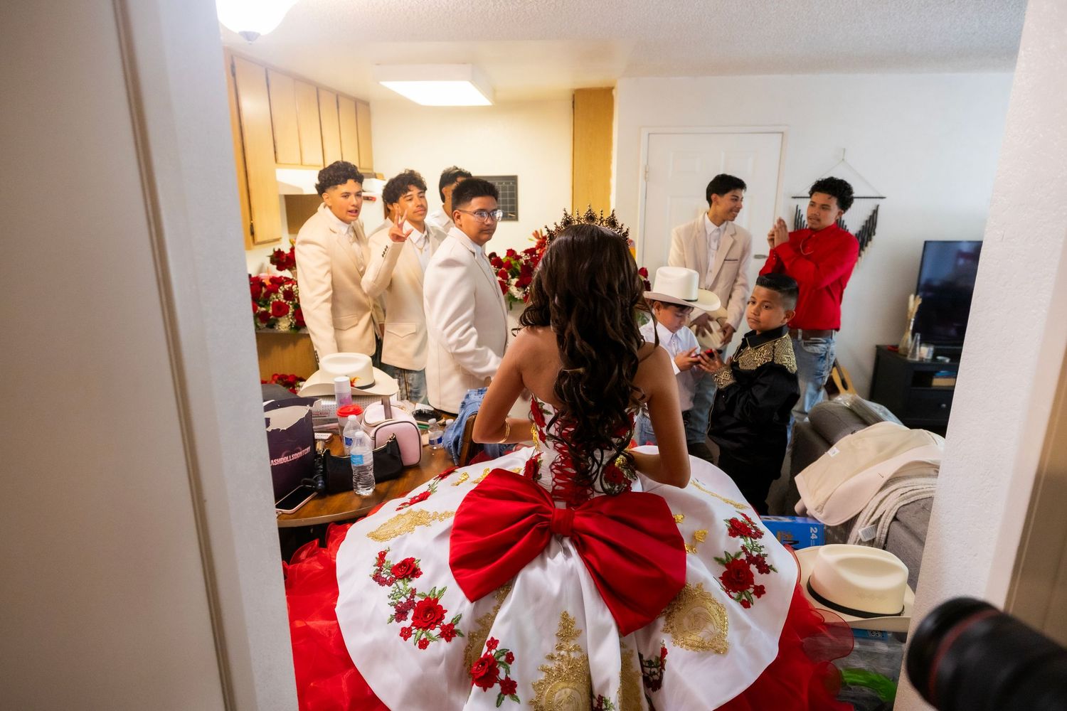 Guests gathered around a table at a formal event with white tablecloths and red decorative accents.