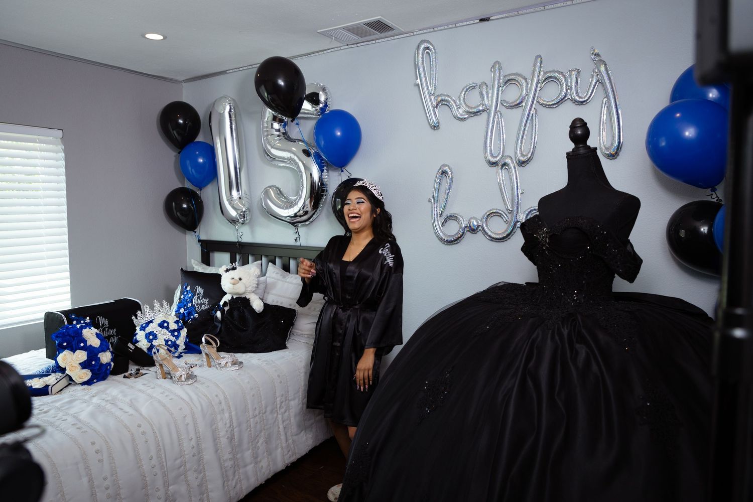 Black and blue balloon decorations adorn a white room for a celebration event.