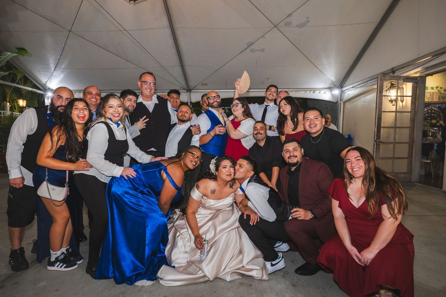 Wedding party poses together for a fun group photo at an evening reception.