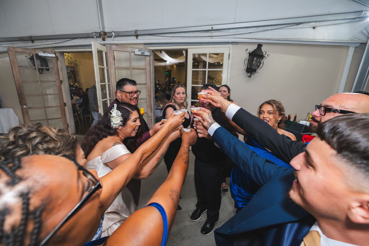 A group of people raise their glasses together in a celebratory toast at a festive gathering.