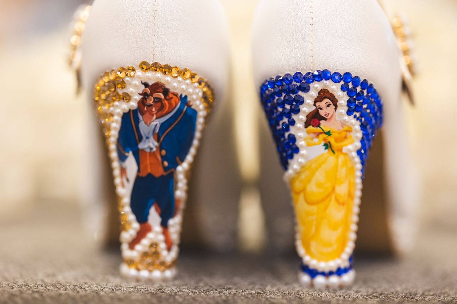 Two decorative drinking glasses featuring Beauty and the Beast characters adorned with crystal embellishments.